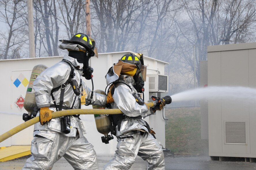 Civilian firefighters Scott Kramer and Jody Meade put out a fake fire during fire fighting training on Nov. 20, 2012. Kramer and Meade are firefighters for the 193rd Special Operations Wing, Middletown, Pa. Kramer is also a Master Sgt. with the Wing. (U.S. Air Force Photo by Tech. Sgt Culeen Shaffer/Released)
