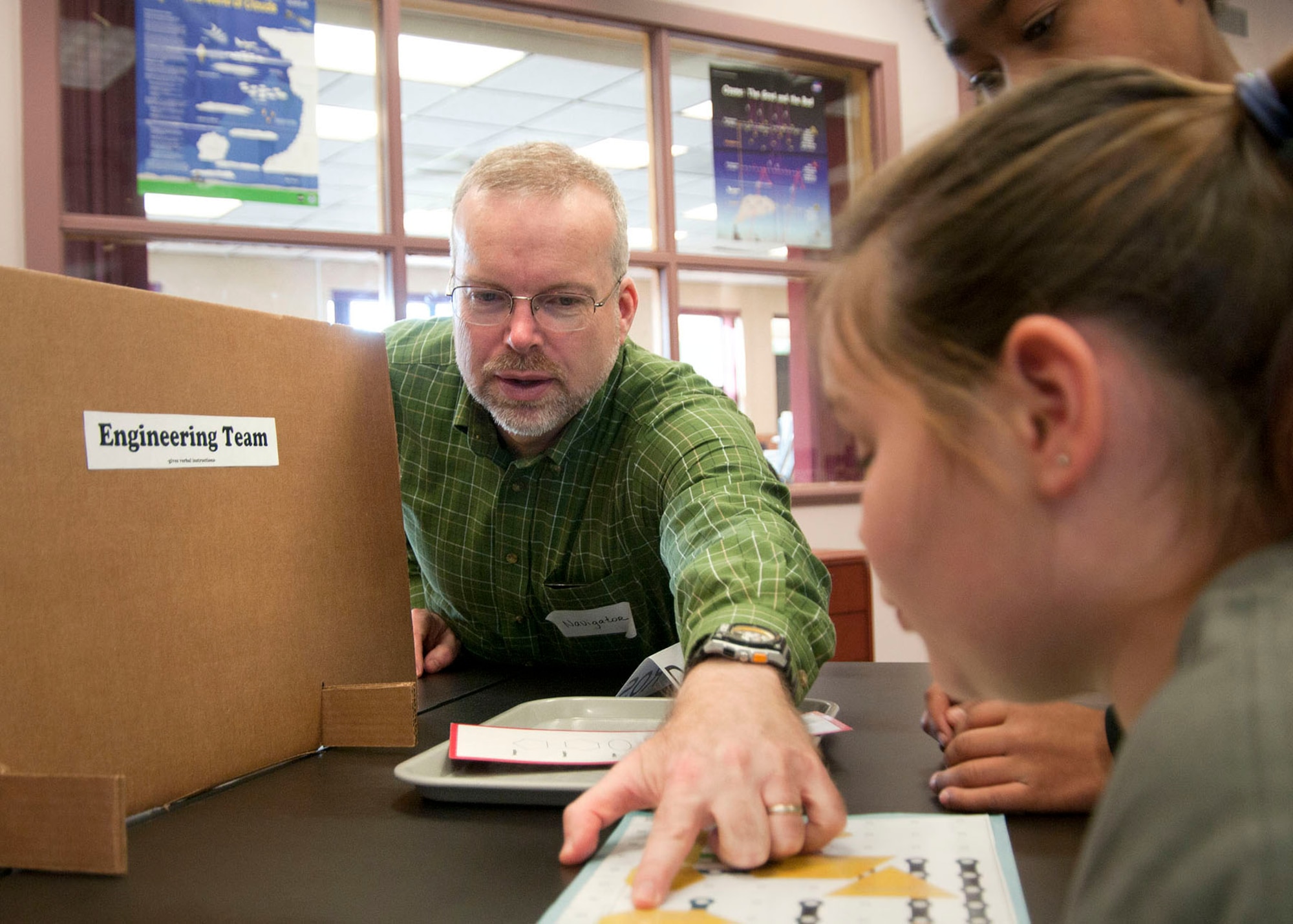 HANSCOM AIR FORCE BASE, Mass. -- Peter Holden, Hanscom STARBASE director, assists fifth grade students from the Dr. A.B. Consentino Middle School in Haverhill, Mass., during an activity at the STARBASE Academy Nov. 19. Students completed an exercise, called circuit board geometry, where two teams worked together in verbal communication but were not able to see what the other team was doing. The lesson reinforced teamwork, communication, geometry, coordinate systems and electric circuits. (U.S. Air Force photo by Mark Wyatt)