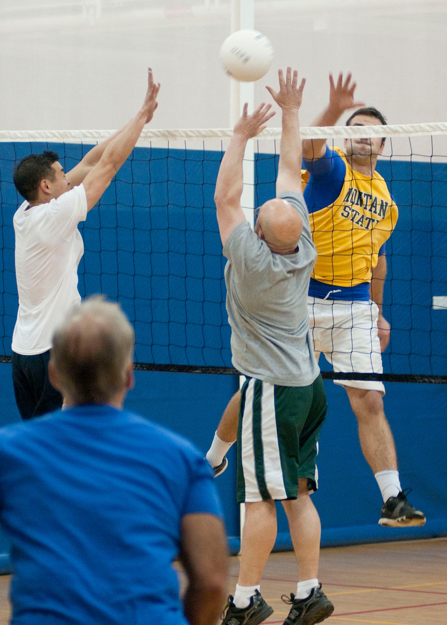 HANSCOM AIR FORCE BASE, Mass. -- 2nd Lt. Jordan Waiwaiole, Air Force Life Cycle Management Center contracting specialist, spikes the ball against two blockers during an intramural volleyball game at the Fitness and Sports Center Nov. 14. AFLCMC defeated the 66th Medical Squadron two games to none. (U.S. Air Force photo by Mark Wyatt)