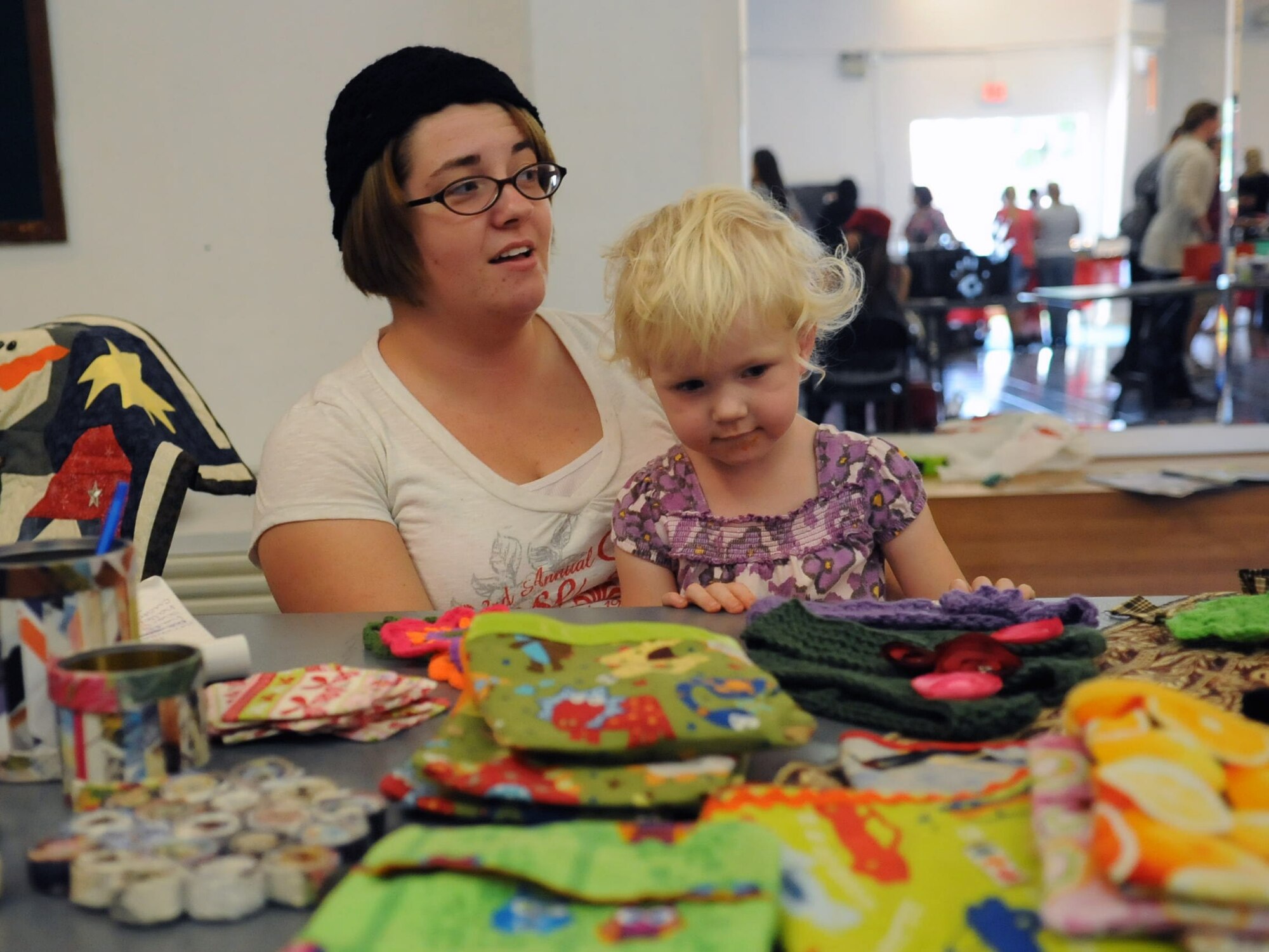 Ashley Mangin and her daughter Emma sit at their table of hand-made goods at the community center's holiday bazaar Nov. 17, 2012 at Incirlik Air Base, Turkey. The event gave Incirlik members the chance to showcase their talents to others. (U.S. Air Force photo by Senior Airman Daniel Phelps/Released)
