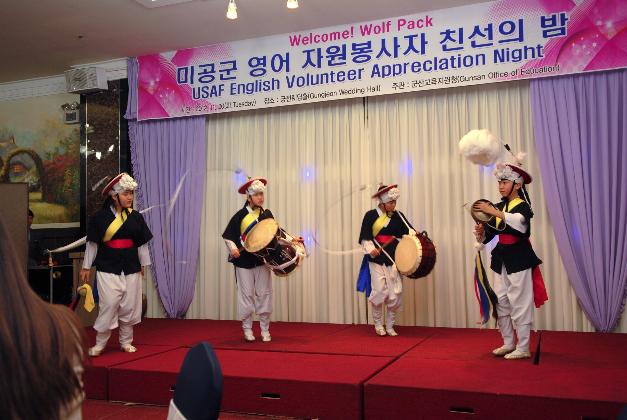 Gunsan City elementary school students wearing traditional Korean attire entertain, 8th Fighter Wing, Kunsan Air Base, Republic of Korea volunteers during an appreciation dinner Nov. 20, 2012. More than 50 Wolf Pack members volunteered their time to help Korean students improve their English. (US Air Force photo/ Staff Sgt. Tong Duong)