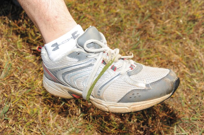 Capt. Kyle Thomas, deputy public affairs officer, MCLB Albany, binds his shoes to his feet using boot bands while wrapping his shoelaces around his ankles. More than 550 people participated in Marine Corps Logistics Base Albany’s first Dirty Devil Dog Mud Run, Nov. 17. Sloshing through canals, jumping barricades and low crawling through mud pits were just a few of the obstacles runners endured.

