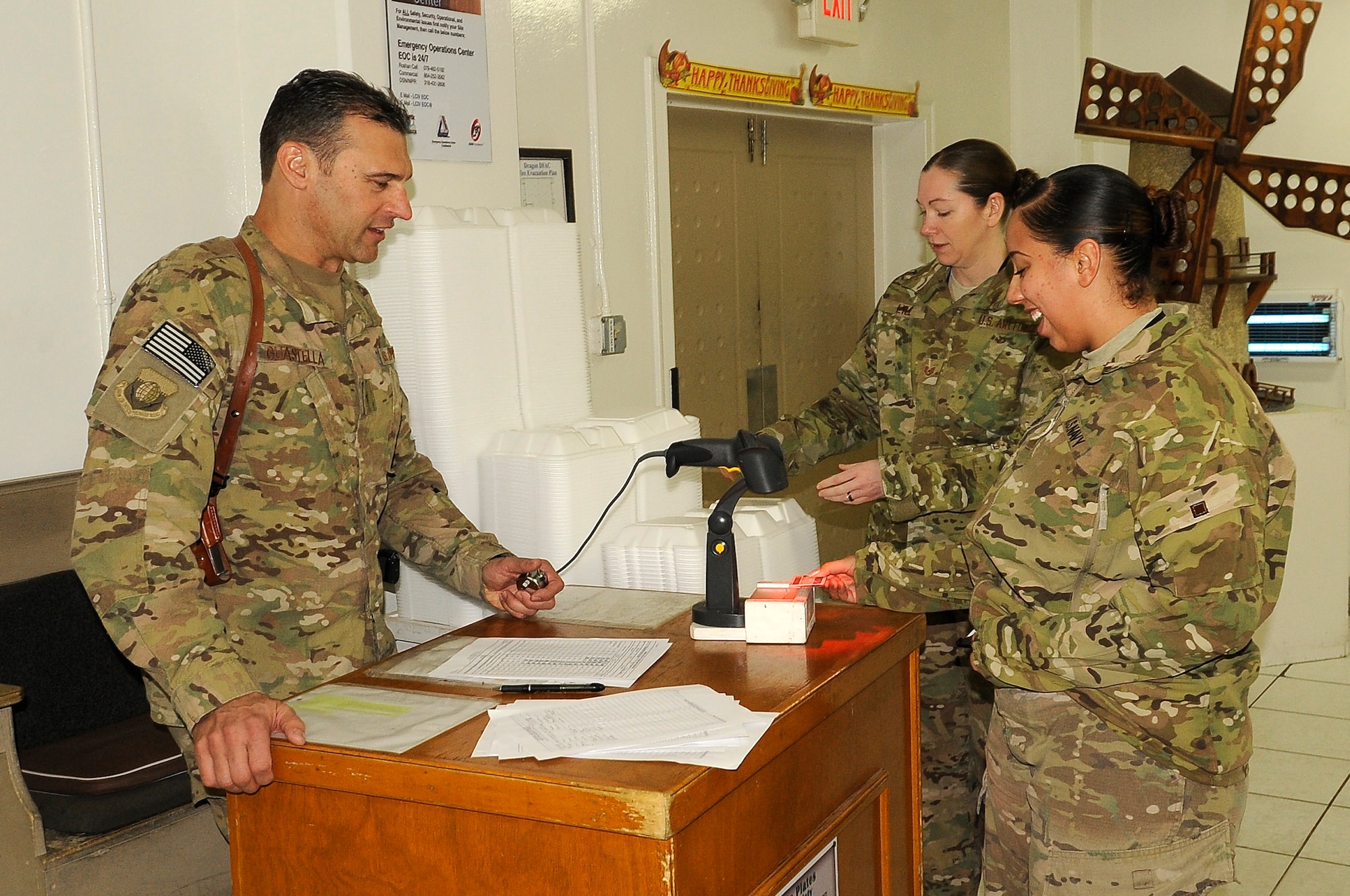 Brig. Gen. Joseph Guastella, 455th Air Expeditionary Wing commander (left), checks ID’s and greets service members during a Thanksgiving Day celebration. 455 AEW's leadership served meals on Thanksgiving as a way to boost the morale of the servicemen and women. (U.S. Air Force photo/Senior Airman Chris Willis)