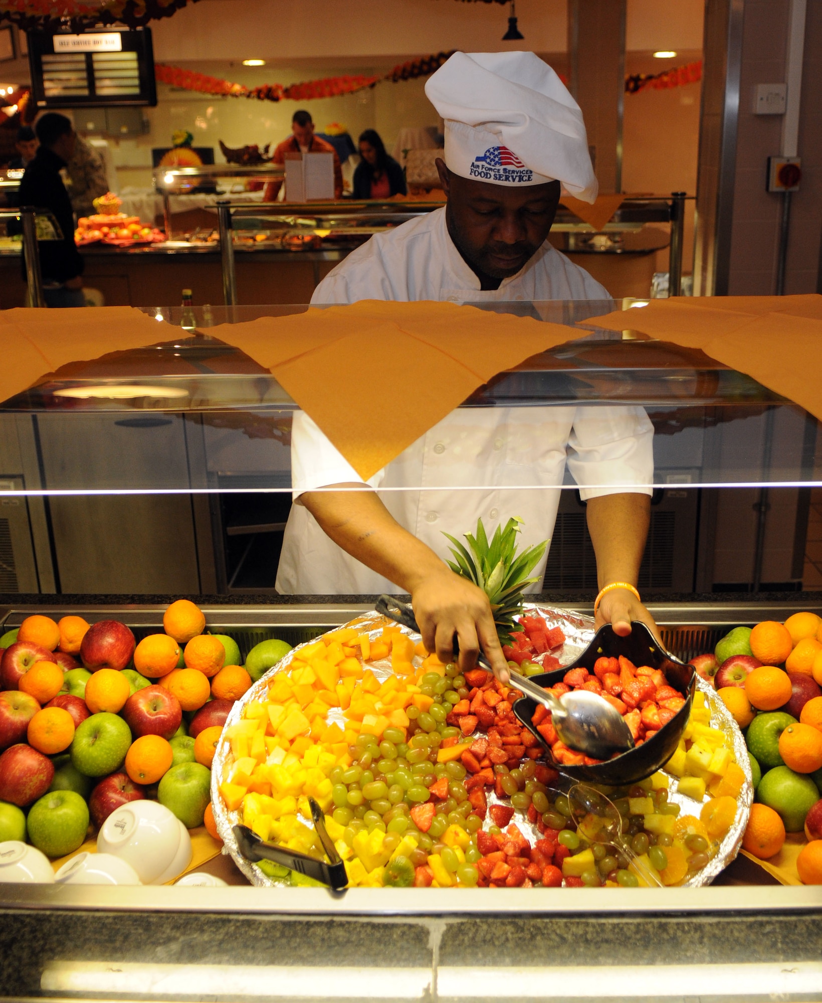 Peter Sanganza, 100th Force Support Squadron contract chef, replenishes supplies of fresh fruit for the Thanksgiving lunch served in celebration of the American holiday Nov. 22, 2012, at the Gateway Dining Facility, RAF Mildenhall, England. The 100th FSS prepared the feast to allow American service members and their families stationed in England to enjoy the holiday. (U.S. Air Force photo by Staff Sgt. Austin M. May/Released)