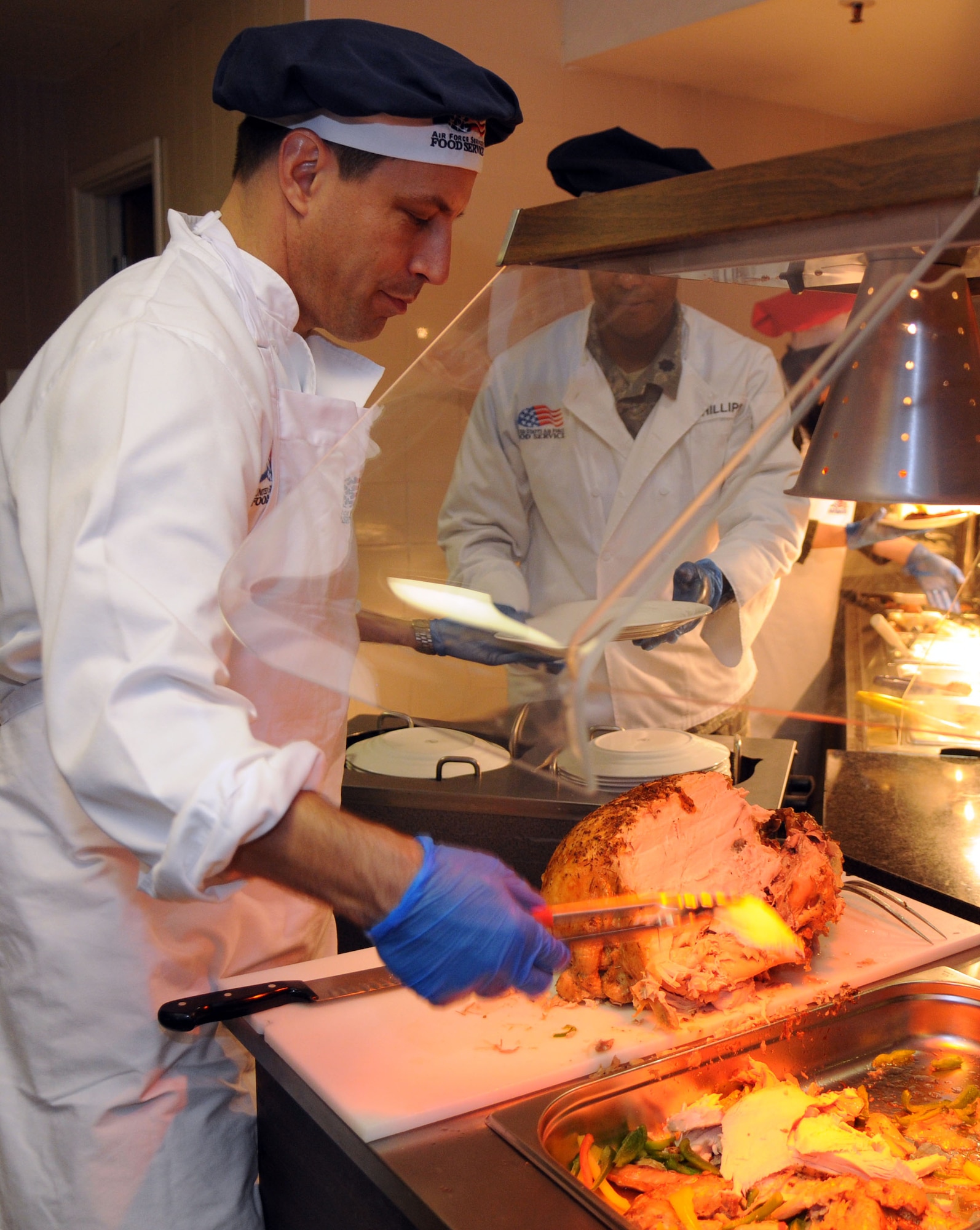 Col. Christopher Kulas, 100th Air Refueling Wing commander, carves turkey during the Thanksgiving lunch served in celebration of the American holiday Nov. 22, 2012, at the Gateway Dining Facility at RAF Mildenhall, England. Several distinguished visitors joined the dining facility staff to serve lunch to around 350 members of Team Mildenhall. (U.S. Air Force photo by Staff Sgt. Austin M. May/Released)