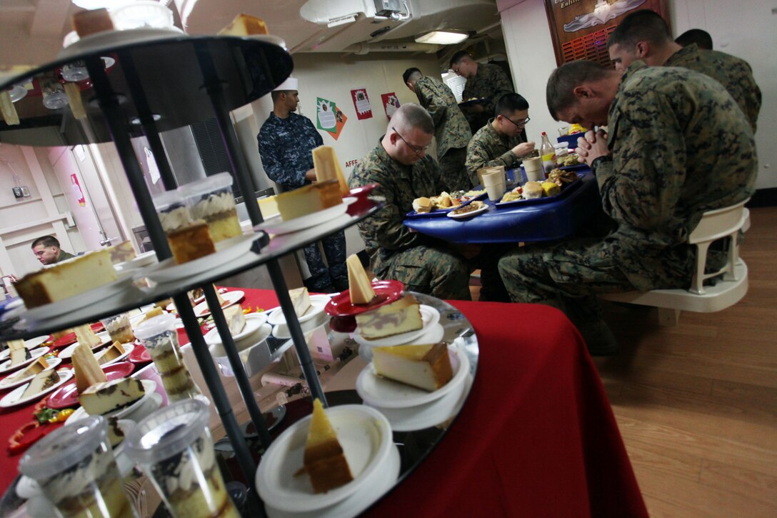 Marines with the 24th Marine Expeditionary Unit say grace before enjoying a Thanksgiving feast aboard the USS New York, Nov. 22, 2012. All three ships of the Iwo Jima Amphibious Ready Group served Thanksgiving dinner to their crew. The 24th Marine Expeditionary Unit is currently deployed as an expeditionary crisis response force in support of maritime security operations and theater security cooperation efforts in the U.S. 6th Fleet area of responsibility. (U.S. Marine Corps photo by Staff Sgt. Robert L. Fisher III)