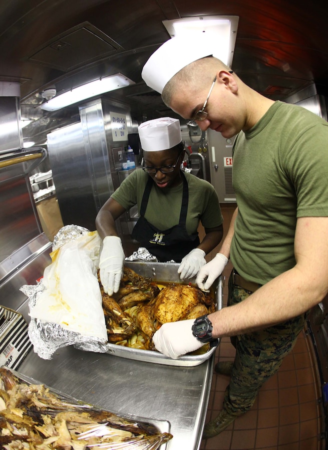 Lance Cpls. LaTrace Thompson, left, a food service specialist, and Ethan Sherer, a radio operator, both with the 24th Marine Expeditionary Unit, prepare turkeys on Thanksgiving Day for the Marines and Sailors aboard the USS New York, Nov. 22, 2012. All three ships of the Iwo Jima Amphibious Ready Group served Thanksgiving dinner to their crew. The 24th Marine Expeditionary Unit is currently deployed as an expeditionary crisis response force in support of maritime security operations and theater security cooperation efforts in the U.S. 6th Fleet area of responsibility. (U.S. Marine Corps photo by Cpl. Michael Petersheim)