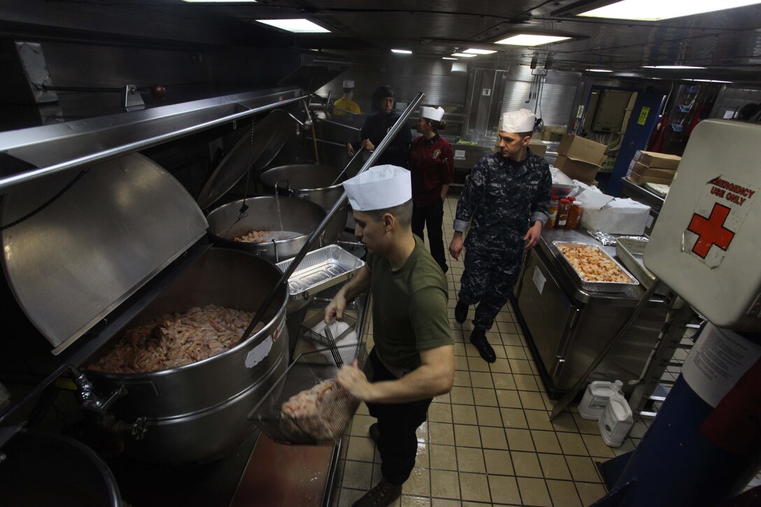 Marines with the 24th Marine Expeditionary Unit and Sailors with the Iwo Jima Amphibious Ready Group prepare for the Thanksgiving dinner aboard the amphibious assault ship USS Iwo Jima, Nov. 22, 2012. The 24th MEU is deployed with the Iwo Jima ARG and is currently in the 6th Fleet area of responsibility. Since deploying in March, they have supported a variety of missions in the U.S. Central, Africa and European Commands, assisted the Navy in safeguarding sea lanes, and conducted various bilateral and unilateral training events in several countries in the Middle East and Africa. (U.S. Marine Corps photo by Lance Cpl. Tucker S. Wolf/Released)