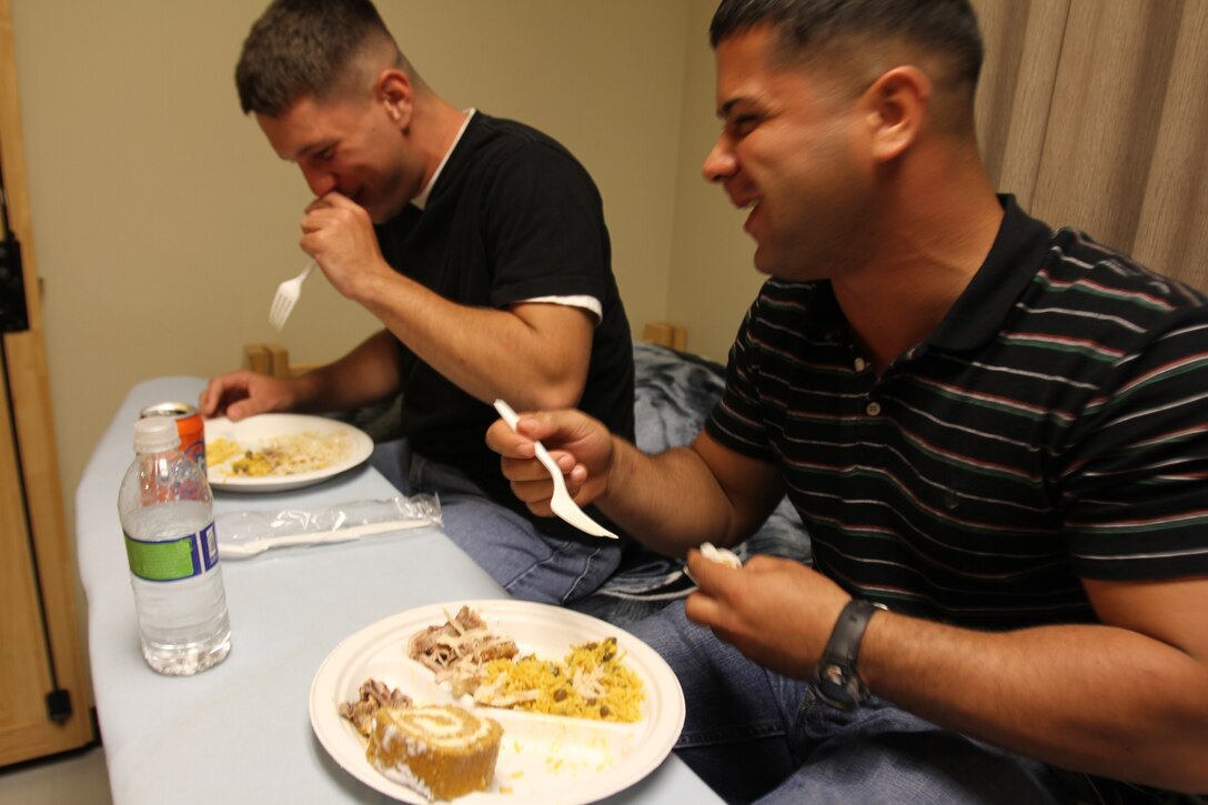 Lance Cpl. Joseph Jarman (left), a motor transportation operator and native of Meckberk County, Virg., and Pfc. Edison Ramosgoubert, a water purification specialist and a native of Long Island, N.Y., both with Combat Logistics Battalion 31, 31st Marine Expeditionary Unit, enjoy a warm, home-cooked Thanksgiving meal, prepared by the spouses of senior Marines and Sailors in the unit as part of a Taste of Home event here, Nov. 20. The Taste of Home program, which is conducted quarterly by the unit, gives the single Marines and Sailors in the unit a chance to enjoy some of the familiar flavors of their favorite holidays. The 31st MEU is the only continuously forward-deployed MEU and is the Marine Corps’ force in readiness in the Asia-Pacific region.