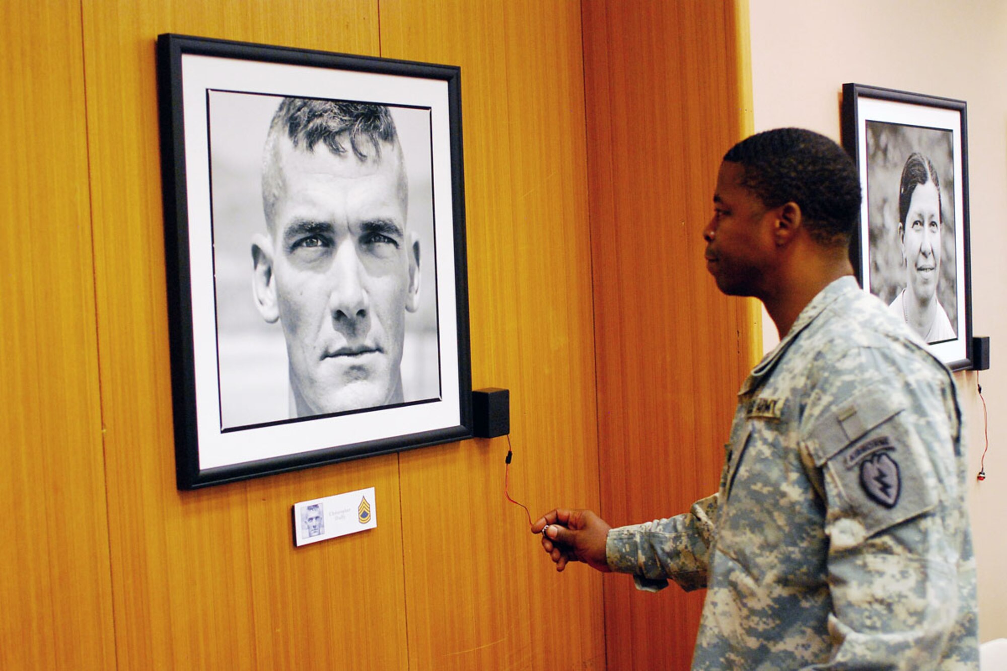 Army Master Sgt. Gary Mullins, Headquarters and Headquarters Company, 4th Brigade Combat Team (Airborne), 25th Infantry Division, listens to the commentary Nov. 13 accompanying the portrait of his friend, Sgt. 1st Class Christopher Duffy, 1st Battalion (Airborne), 501st Infantry Regiment, at the 4-25th ABCT headquarters building. (U.S. Army photo/Staff Sgt. Jeffrey S. Smith)