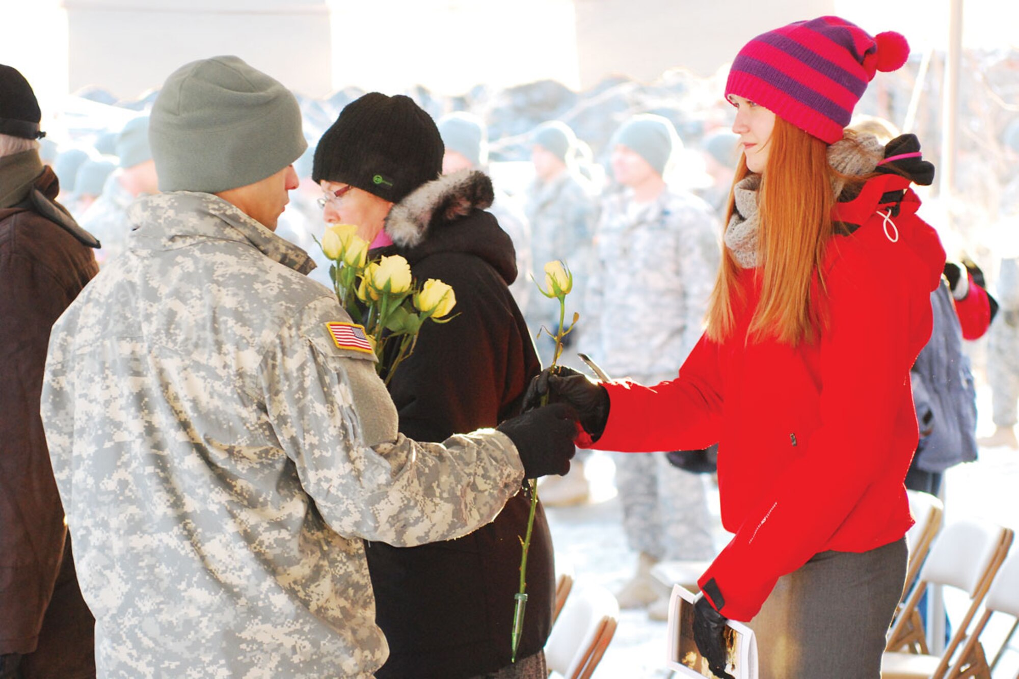 Army 2nd Lt. Alfred Gee Jr., an operations officer with the 4th Brigade Combat Team (Airborne), 25th Infantry Division, hands a rose to a Gold-Star family member during a memorial ceremony hosted Nov. 16 at the brigade’s headquarters building at Joint Base Elmendorf-Richardson. The memorial ceremony honored 14 Soldiers who were killed in action during the brigade’s recent deployment to Afghanistan. (U.S. Army photo by Staff Sgt. Jeffrey S. Smith)