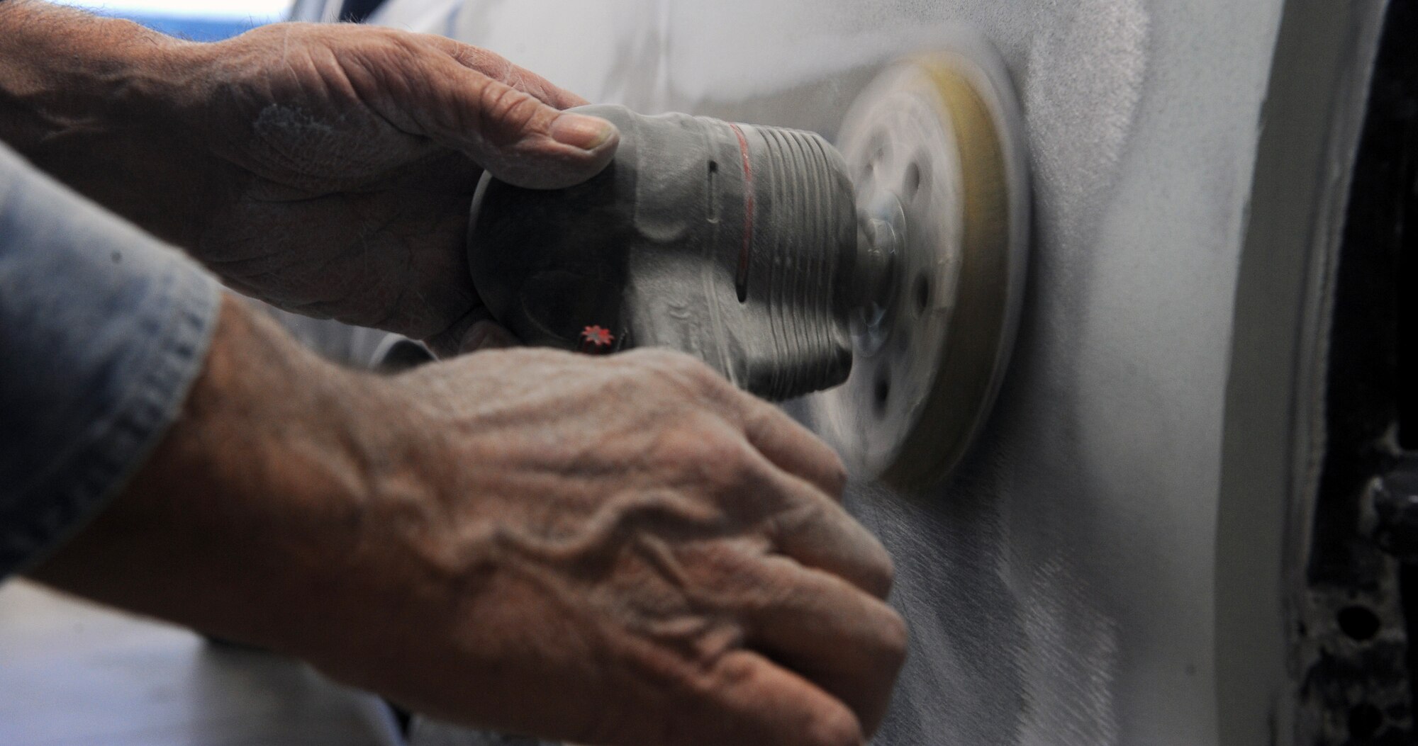 WHITEMAN AIR FORCE BASE, Mo -- A member of the 509th Logistics Readiness Squadron vehicle maintenance shop sands the back of a truck in the auto body section, Nov. 20. Vehicle maintenance has its own body shop to repair government vehicles and repaint vehicles if needed. (U.S. Air Force photo/Airman 1st Class Bryan Crane) (Released)