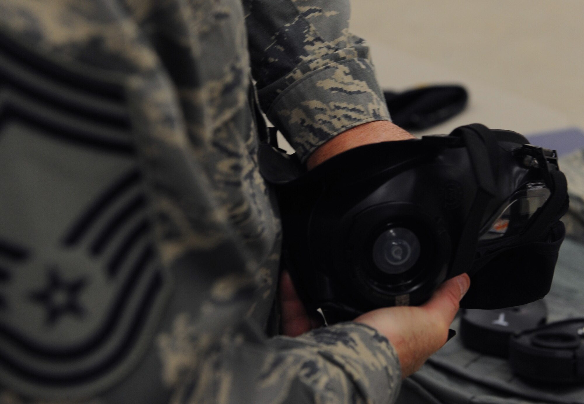 WHITEMAN AIR FORCE BASE, Mo. -- Chief Master Sgt. Dwight Hardy, 509th Munitions Squadron, checks his M-50 chemical mask for discrepancies that could make the mask ineffective during a training class Nov. 13. The M-50 chemical masked replaced the MCU-2A/P chemical mask in 2009. (U.S. Air Force photo/Airman 1st Class Bryan Crane) (Released)