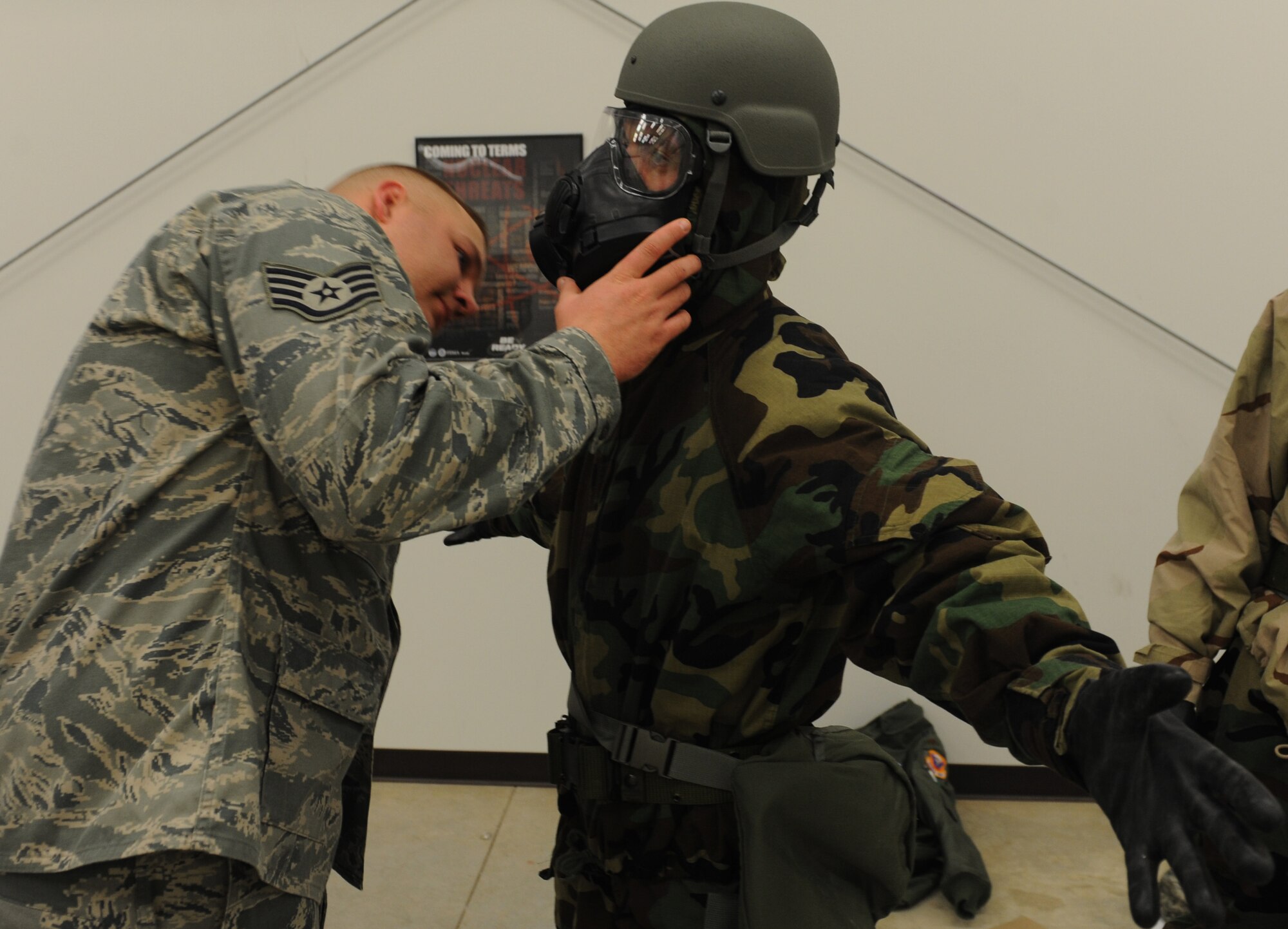WHITEMAN AIR FORCE BASE, Mo. -- Staff Sgt. Cody Foreman, 509th Civil Engineer Squadron Chemical, Biological, Radiological and Nuclear instructor, checks an Airmen to insure he properly put on his Mission Oriented Protective Posture gear during a CBRN training, Nov. 13. Chemical warfare training teaches Airmen how to survive and operate in hazardous environments whether deployed or at home station. (U.S. Air Force photo/Airman 1st Class Bryan Crane) (Released)