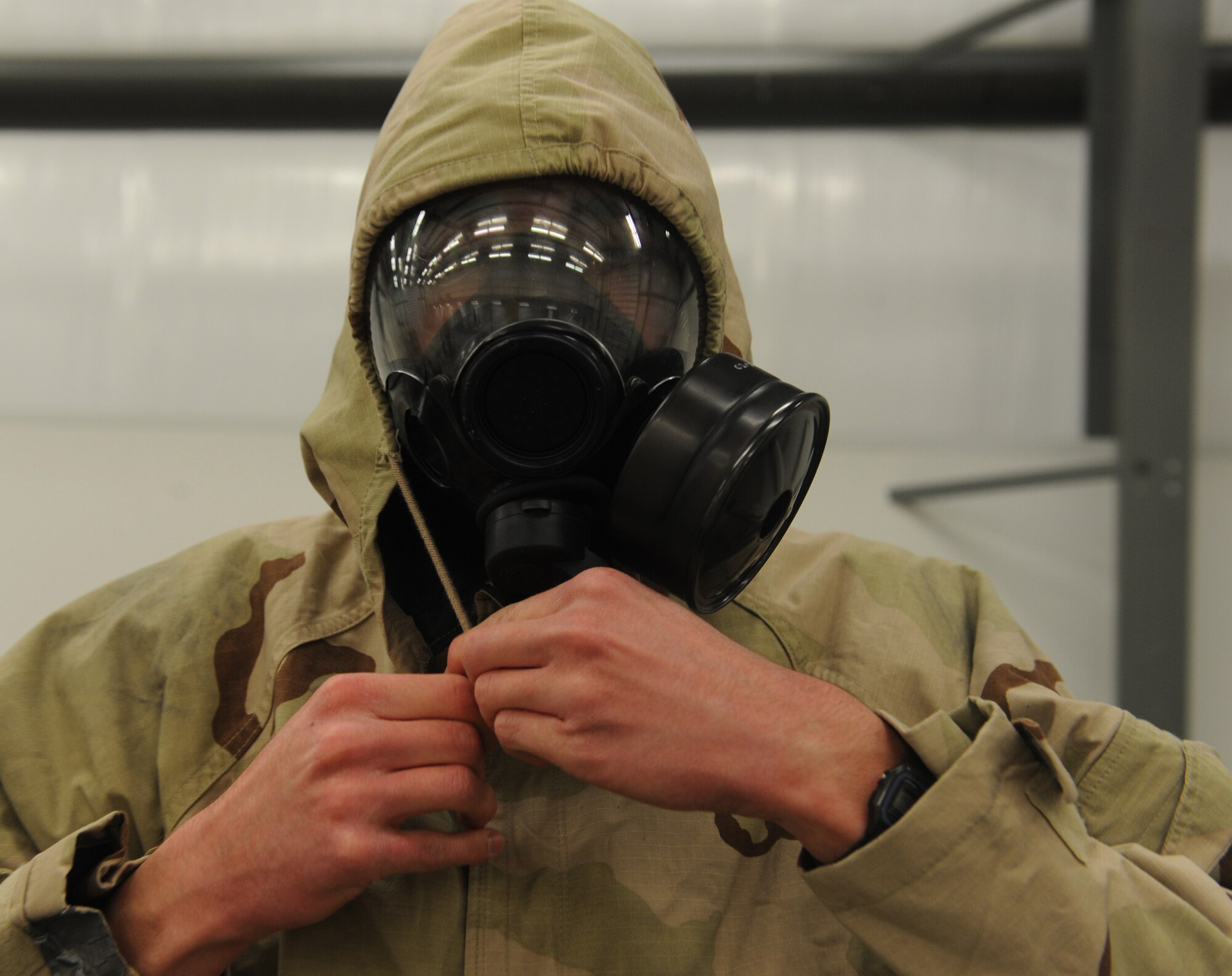 WHITEMAN AIR FORCE BASE, Mo. --Senior Airman Nathan Carns, 509th Maintenance Squadron low observable technician, ties his hood tight over his M-50
chemical mask during a Chemical, Biological, Radiological and Nuclear training, Nov. 13. CBRN classes are conducted to ensure all base personnel are prepared in case of an actual attack. (U.S. Air Force photo/Airman 1st Class Bryan Crane) (Released)