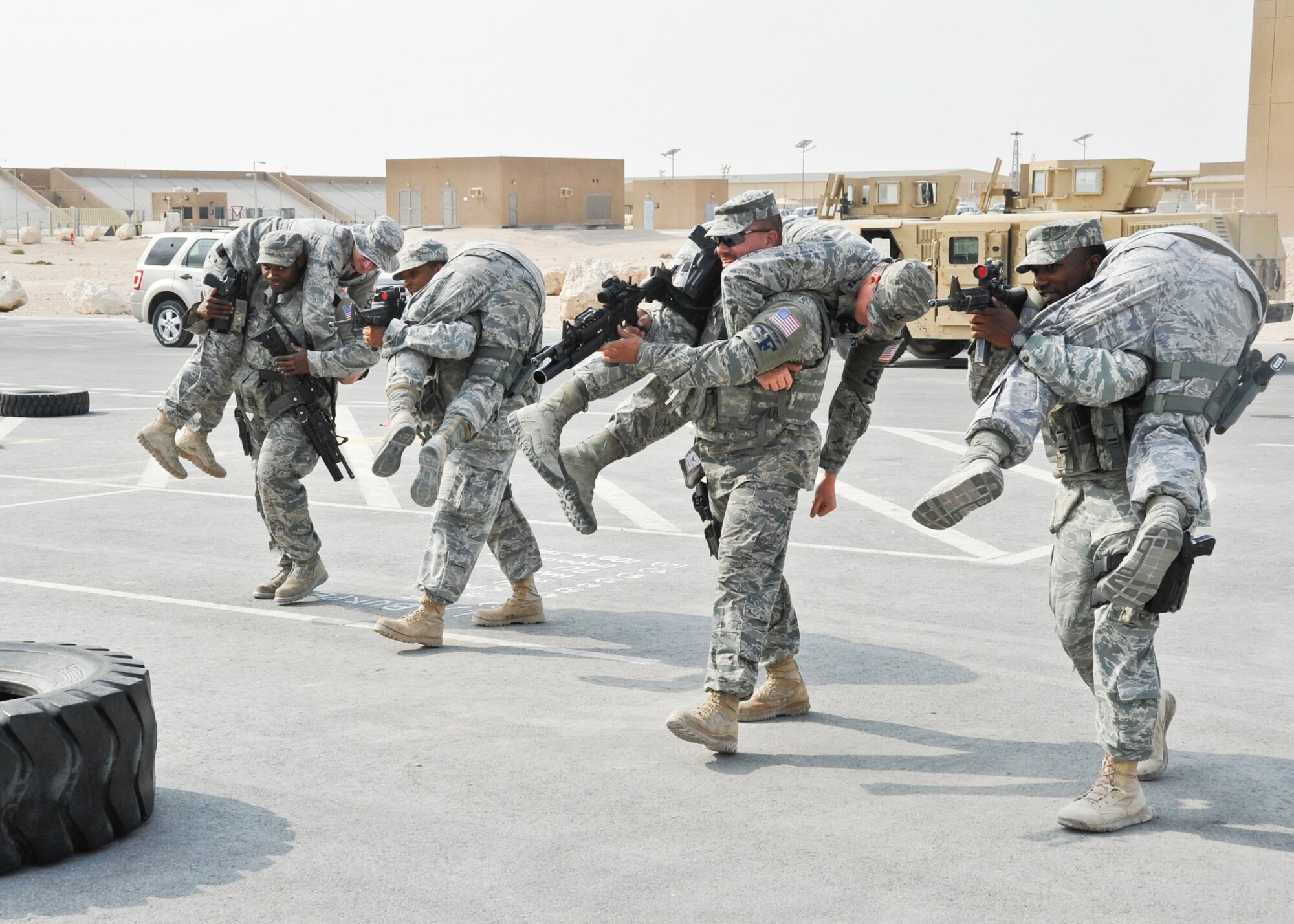 (Left to Right) Senior Airman Derrick Griggs, Staff Sgt. Edgardo Rosero, Tech. Sgt. Dominic Vecchi and Staff Sgt. Donald Gilmore, all 379th Expeditionary Security Forces Squadron Quick Reaction Force members, carry other QRF members during their daily physical training Nov. 20, 2012. QRF members conduct rigorous PT to keep themselves in the best possible shape to perform any mission. Their entire PT is conducted with body armor and weapons to simulate real-world situations. Griggs, a native of Muridian, Miss., is deployed from Columbus Air Force Base, Miss. Rosero, a native of Bronx, N.Y., is deployed from Columbus AFB. Vecchi, a native of Cabot, Ark., is deployed from Joint Base McGuire-Dix-Lakehurst, N.J. Gilmore, a native of Florence, S.C., is deployed from Little Rock AFB, Ark. (U.S. Air Force photo/Senior Airman Bryan Swink)