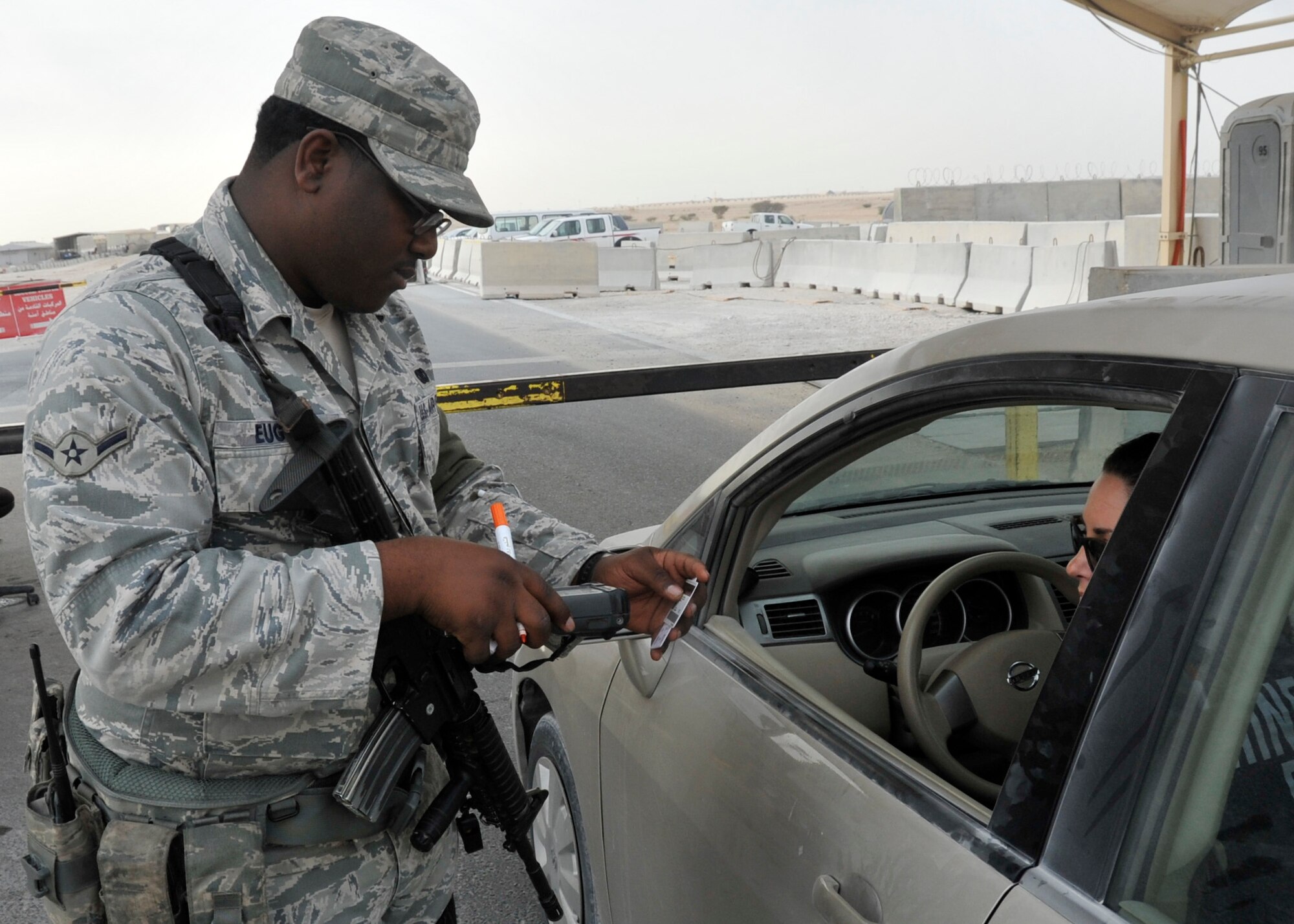 Airman Kardell Eugene, 379th Expeditionary Security Forces Squadron gate guard, scans a Department of Defense Common Access Card into the Defense Biometric Identification System to ensure the driver (and passengers) has proper clearance to enter the installation Nov. 20, 2012. Once cleared through DBIDS, Eugene directs the vehicle to the search pit to have the entire vehicle searched for explosives, drugs and contraband before it can enter the installation. The squadron's vision is to establish the 379th ESFS as the pre-eminent defense force in the Central Command area of responsibility. Eugene, a native of New Orleans, La., is deployed from Vandenburg Air Force Base, Calif. (U.S. Air Force photo/Senior Airman Bryan Swink)