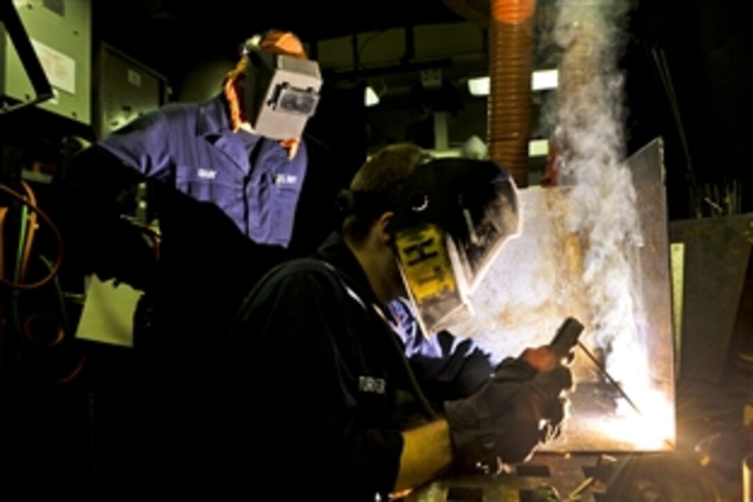 U.S. Navy Seaman Justin Turner, right, shows Seaman Cody Shay how to weld a box in the general workshop aboard the guided-missile destroyer USS Jason Dunham in the Arabian Sea, Nov. 16, 2012. Turner is a hull maintenance technician fireman and Shay is a hull maintenance technician fireman apprentice.