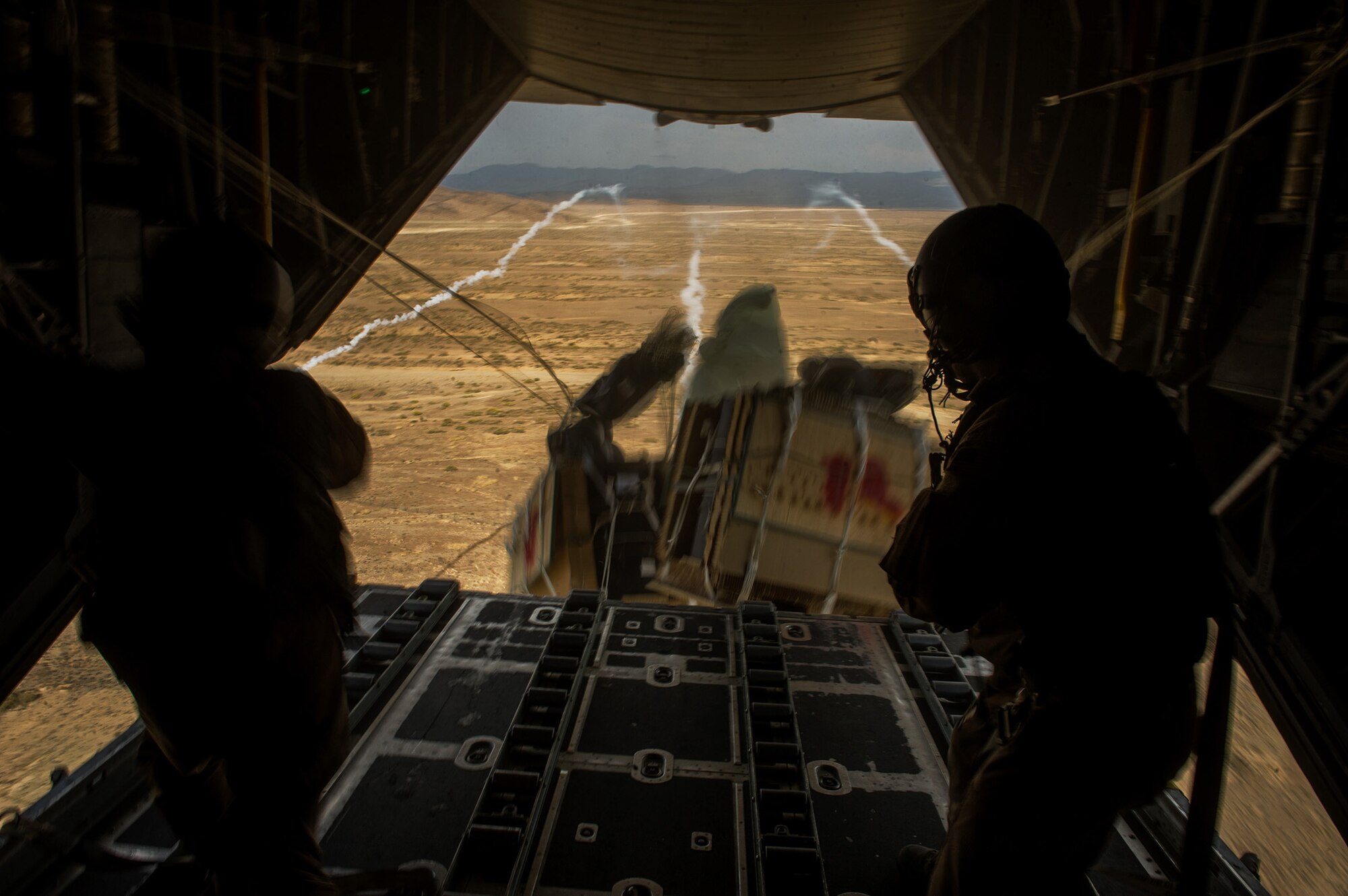U.S. Air Force Airman 1st Class Luke Tucciarone, right, and Staff Sgt. Jacob Barnes, left, both 774th Expeditionary Airlift Squadron loadmasters, push bundles of pallets out of a U.S. Air Force C-130H Hercules Oct. 31, 2012, over Afghanistan. The 774th EAS provides tactical airlift, airdrop and aeromedical evacuation, creating an air bridge for personnel, equipment and supplies. Tucciarone's hometown is Oxford, Conn., and Barnes' hometown is Tionesta, Pa.  (U.S. Air Force photo/Staff Sgt. Jonathan Snyder)