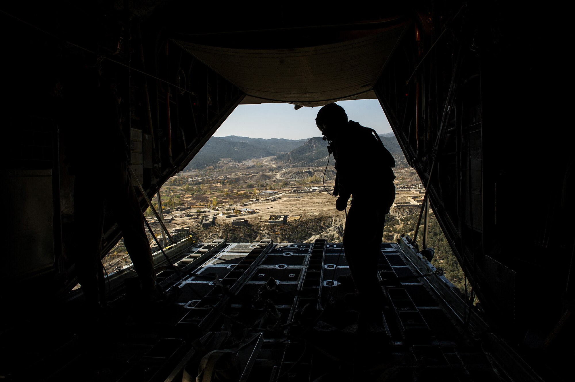 U.S. Air Force Airman 1st Class Luke Tucciarone, 774th Expeditionary Airlift Squadron loadmaster, finishes pushing out pallets from a U.S. Air Force C-130H Hercules Oct. 31, 2012, over Afghanistan. The 774th EAS provides tactical airlift, airdrop and aeromedical evacuation, creating an air bridge for personnel, equipment and supplies. Tucciarone's hometown is Oxford, Conn. (U.S. Air Force photo/Staff Sgt. Jonathan Snyder) 