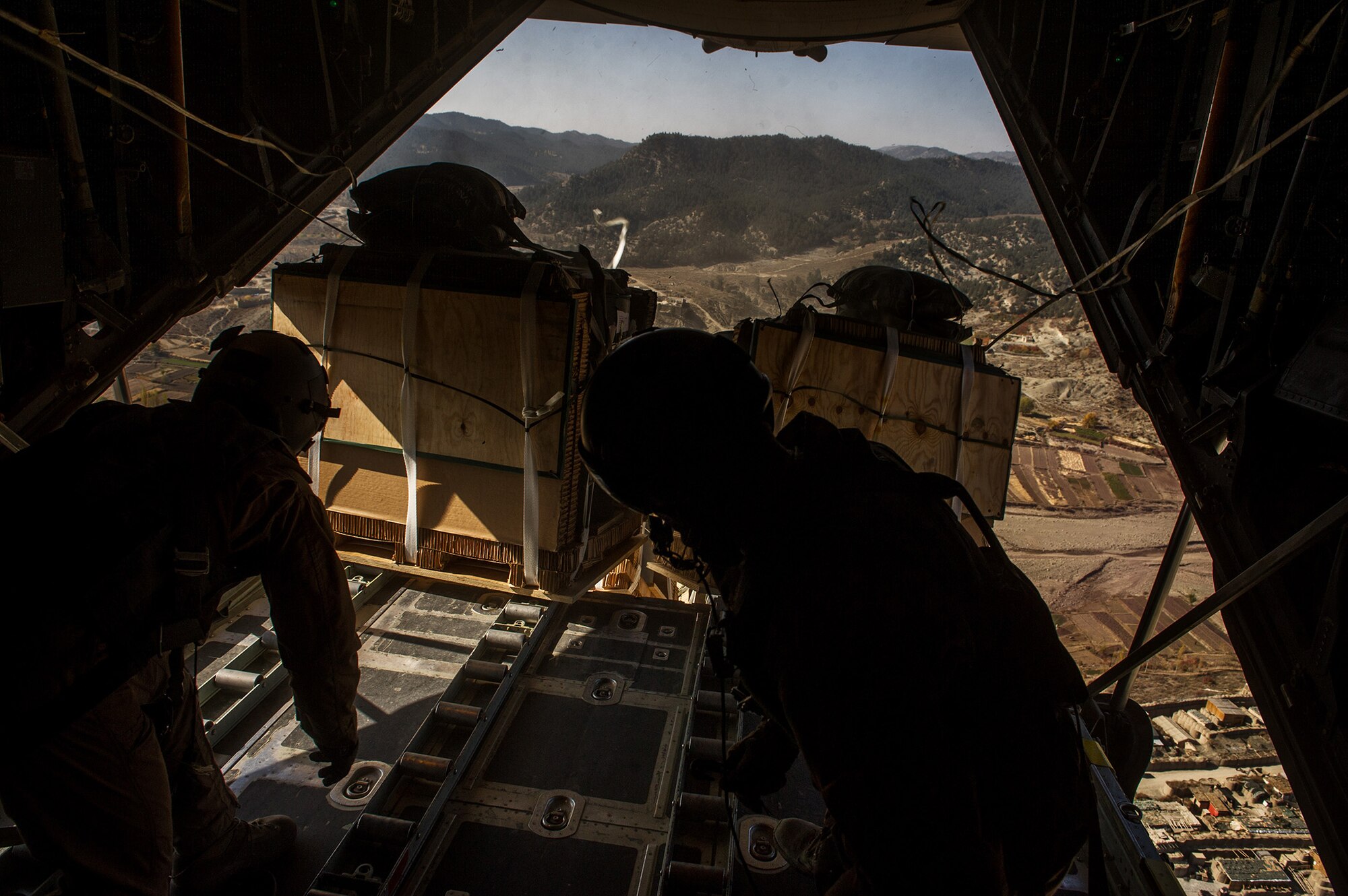 U.S. Air Force Airman 1st Class Luke Tucciarone, right, and Staff Sgt. Jacob Barnes, left, both 774th Expeditionary Airlift Squadron loadmasters, push bundles of pallets out of a U.S. Air Force C-130H Hercules Oct. 31, 2012, over Afghanistan. The 774th EAS provides tactical airlift, airdrop and aeromedical evacuation, creating an air bridge for personnel, equipment and supplies. Tucciarone hometown is Oxford, Conn., and Barnes hometown is Tionesta, Pa. (U.S. Air Force photo/Staff Sgt. Jonathan Snyder)