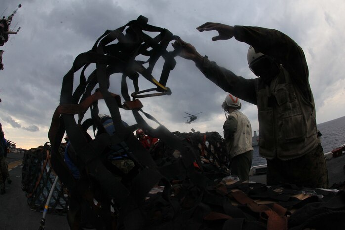 Marines and Sailors unpack food and supplies that were delivered by helicopter to USS Iwo Jima during a replenishment at sea detail, or RAS, Nov. 24, 2012. During the RAS the USS Iwo Jima took on fuel, fresh fruits, vegetables, and supplies from the USNS John Lenthall to sustain the ship and crew while underway. The 24th Marine Expeditionary Unit is deployed with the Iwo Jima Amphibious Ready Group in the 6th Fleet area of responsibility serving as an expeditionary crisis response force capable of a variety of missions, from full-scale combat to evacuations and humanitarian assistance. Since deploying in March, they have supported a variety of missions in the U.S. Central, Africa and European Commands, assisted the Navy in safeguarding sea lanes, and conducted various bilateral and unilateral training events in several countries in the Middle East and Africa. (U.S. Marine Corps photo by Lance Cpl. Tucker S. Wolf/Released) 