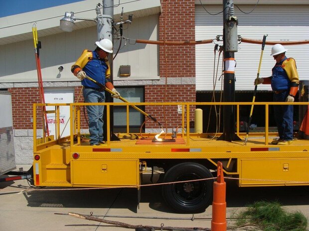 Employees of Pike Electric Company demonstrate how power travels through high voltage lines.
