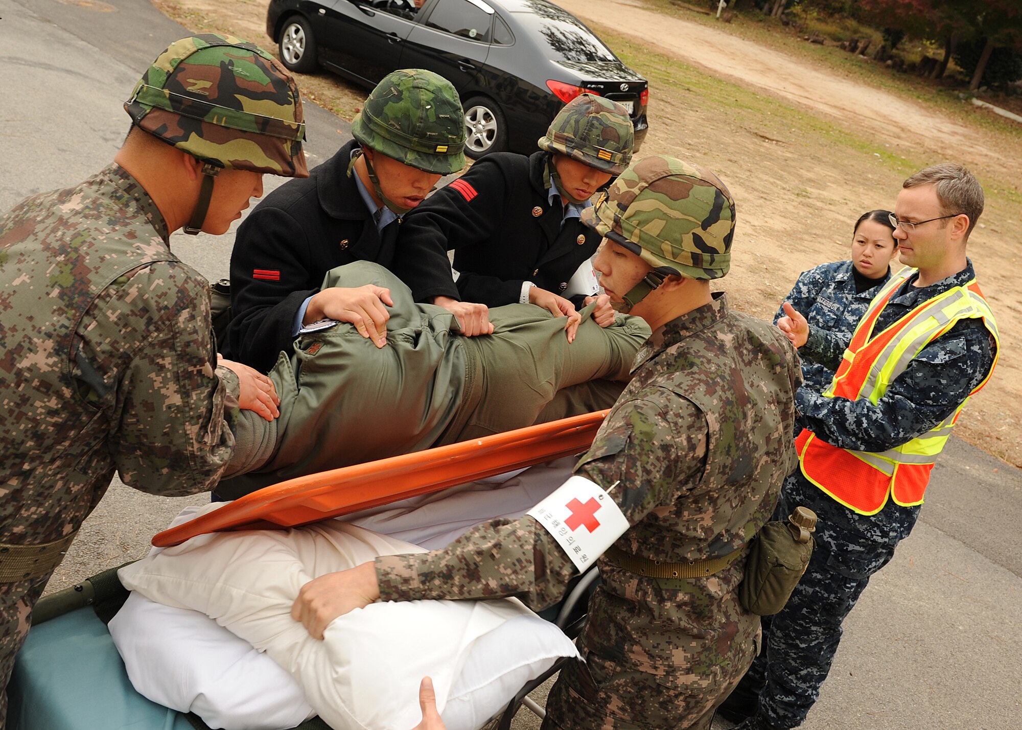 Members of the US and Republic of Korea Navy move a patient onto a litter during a training exercise on Chinhae Naval Station, ROK, Nov. 21, 2012. This was part of a joint training exercise involving  personnel from the US Air Force, US Army, US Navy and ROK Navy. (U.S. Air Force photo/Staff Sgt. Jonathan Fowler)