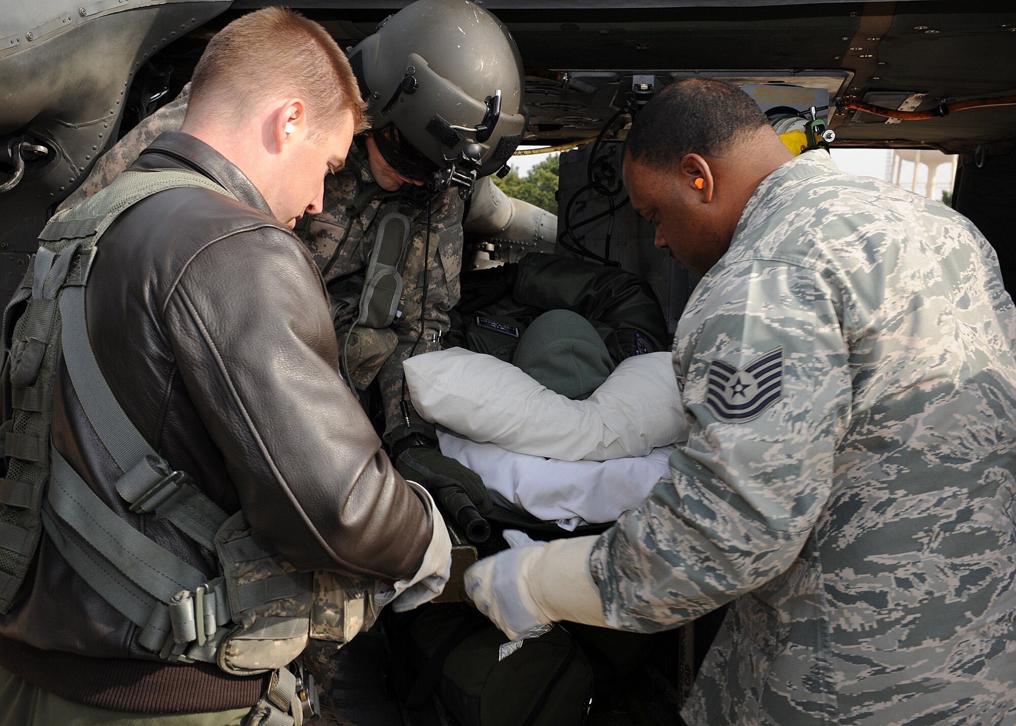 US Air Force Capt. Michael Koroscil, 80th Fighter Squadron, US Army Sgt. Joshua Threadgillz, C Company 3rd Battalion 2nd Combat Air Brigade, and USAF Tech. Sgt. Ernest Veil Jr., 8th Medical Operations Squadron, secure USAF Maj. Franklin Waddell, 8th MDOS, into a UH-60Q Black Hawk during a training exercise on Kunsan Air Base, Republic of Korea, Nov. 21, 2012. This was part of a joint training exercise with personnel from the US Air Force, US Army, US Navy and ROK Navy. (U.S. Air Force photo/Staff Sgt. Jonathan Fowler)