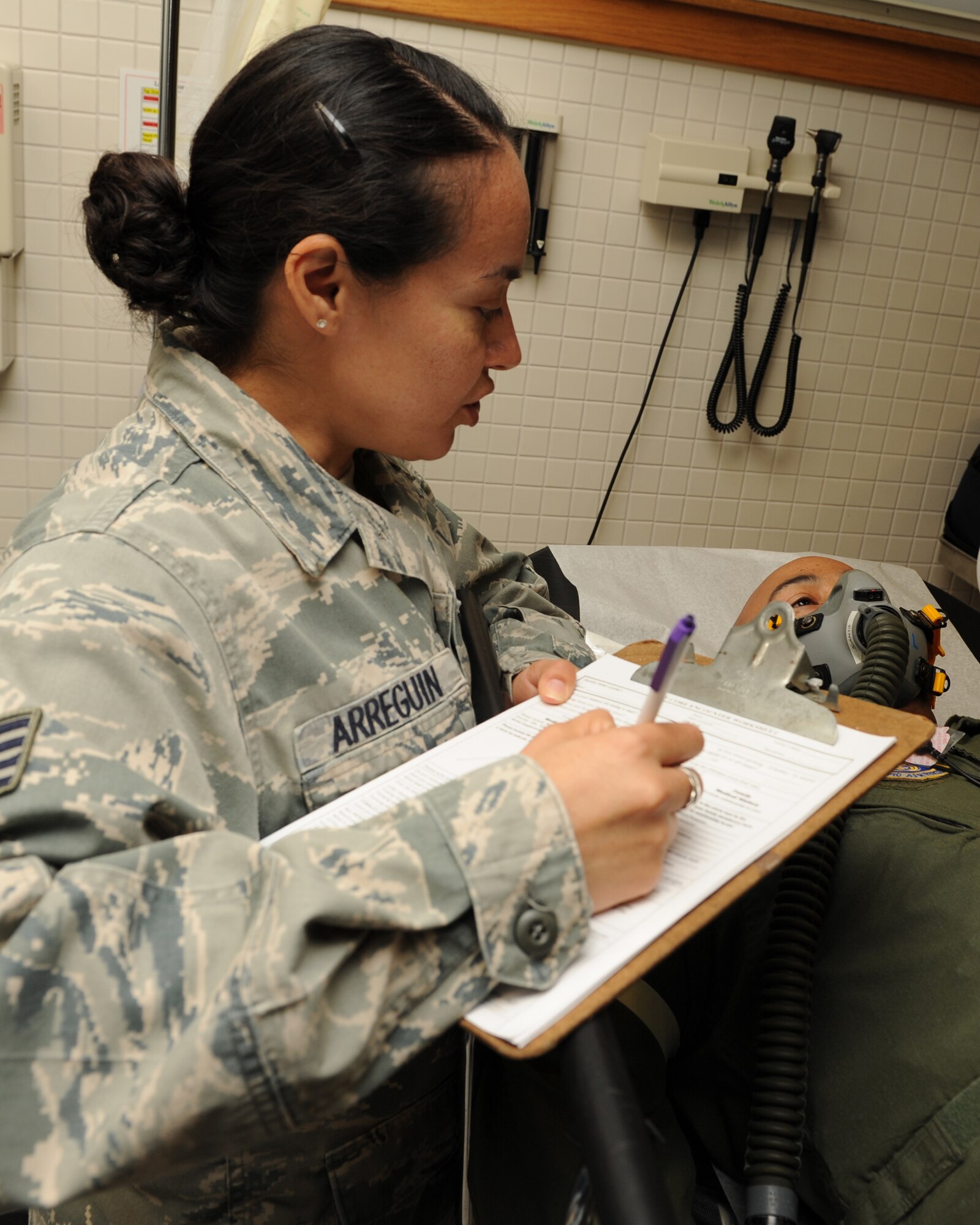 Staff Sgt. Maria Arreguin, 8th Medical Operations Squadron, takes down medical information about Maj. Franklin Waddell, 8th MDOS, during a training exercise on Kunsan Air Base, Republic of Korea, Nov. 21, 2012. Waddell was participating as the “patient” during a medical evacuation exercise. (U.S. Air Force photo/Staff Sgt. Jonathan Fowler)