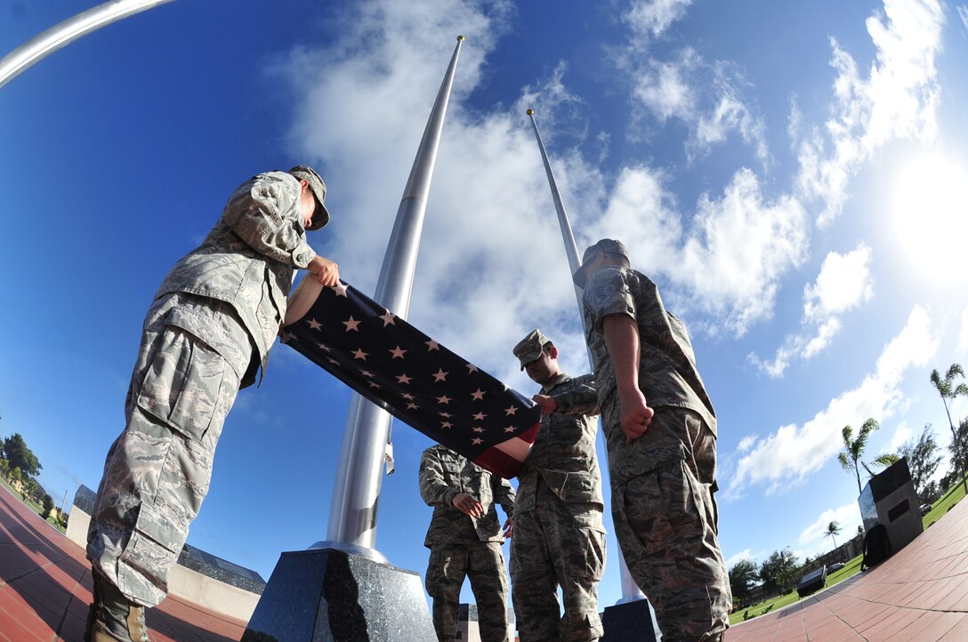 ANDERSEN AIR FORCE BASE, Guam—Staff Sgt. Peter Pleasanton (center), 36th Munitions Squadron, instructs Airman 1st Class Mauricio Perez (right), 36th Operations Support Squadron, on flag folding procedures for retreat ceremonies during the Andersen Blue Knights Honor Guard weekly training Nov. 14. The base honor guard displays the importance of military customs and courtesies, dress and appearance, and drills and ceremonies. (U.S. Air Force photo by Staff Sgt. Alexandre Montes/Released)