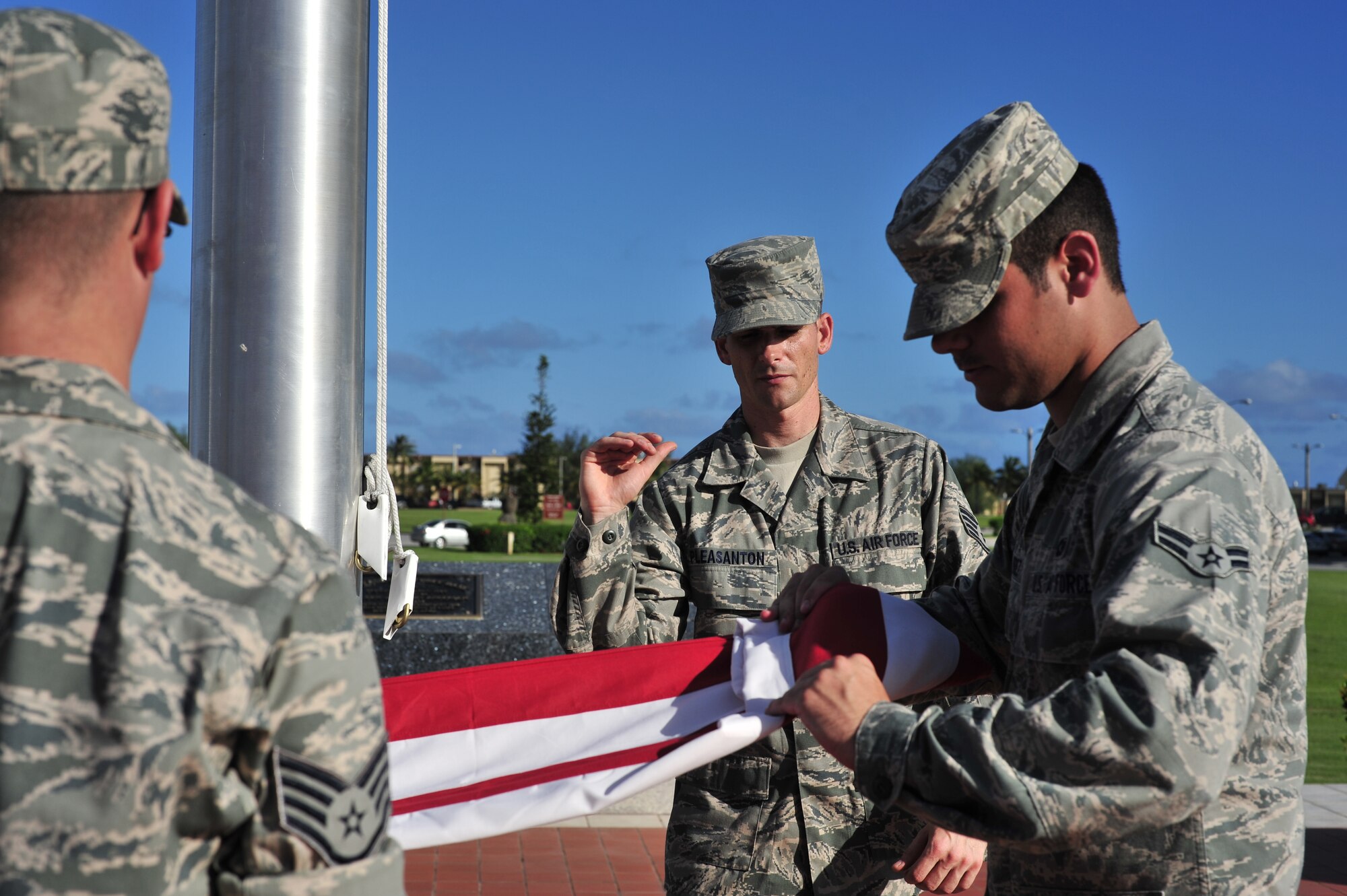 ANDERSEN AIR FORCE BASE, Guam—Staff Sgt. Peter Pleasanton (center), 36th Munitions Squadron, instructs Airman 1st Class Mauricio Perez (right), 36th Operations Support Squadron, on flag folding procedures for retreat ceremonies during the Andersen Blue Knights Honor Guard weekly training Nov. 14. The base honor guard displays the importance of military customs and courtesies, dress and appearance, and drills and ceremonies. (U.S. Air Force photo by Staff Sgt. Alexandre Montes/Released)