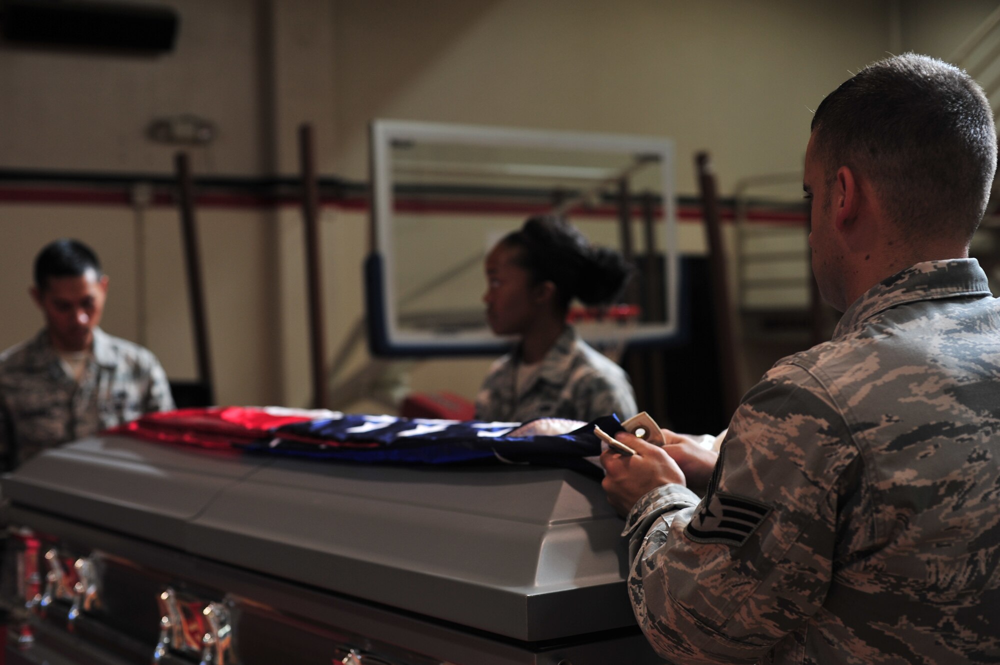 ANDERSEN AIR FORCE BASE, Guam-- Staff Sgt. Eric Reagan (right), 36th Communications Squadron, Airman First Class Lashanda Tillman and  Senior Airman Kenneth Cabanas, both from the 36th Maintenance Squadron, prepare to cover a casket during their weekly Blue Knights Honor Guard training Nov. 14. The honor guard displays the importance of military customs and courtesies, dress and appearance, and drill and ceremonies. (U.S. Air Force photo by Staff Sgt. Alexandre Montes/Released)