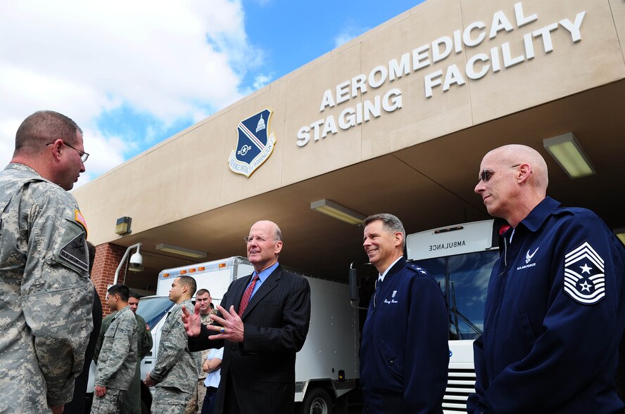 U.S. Navy Vice Admiral (ret.) Norb Ryan, Military Officers Association of America president, 79th Medical Wing Commander Maj. Gen. Gerard Caron and Chief Master Sgt. Kevin McCoy, 79th MDW command chief speak with Sgt. 1st Class Tommy Bish, Military District of Washington Joint Force Headquarters Army Liaison Team member, during a visit to the 779th Medical Group Aeromedical Staging Facility, Oct. 16, at Joint Base Andrews, Md. The ASF is manned by a multiservice military team comprised of anesthesiologists, mental health care providers, flight surgeons, nurses, medical technicians, health service administrators, chaplains, dietary technicians and Marine Corps and Army liaisons. (U.S. Air Force photo by Senior Airman Steele C. G. Britton)