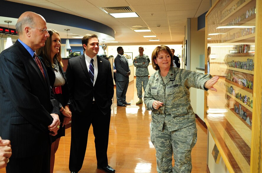 Maj. Nancy Salmans, 779th Medical Group Aeromedical Staging Facility commander, shows wounded warriors' coins to U.S. Navy Vice Admiral (ret.) Norb Ryan, Military Officers Association of America president, Kristen Wisniewski, MOAA assistant director, and U.S. Army Capt. Clayton Hinchman, MOAA deputy director, during a visit to the ASF, Oct. 16, at Joint Base Andrews, Md. The 779th MDG ASF team members were awarded the MOAA 2012 Community Heroes Award in the Military Caregivers category recently for their endless dedication to helping wounded warriors returning from overseas everyday at JBA. (U.S. Air Force photo by Senior Airman Steele C. G. Britton)