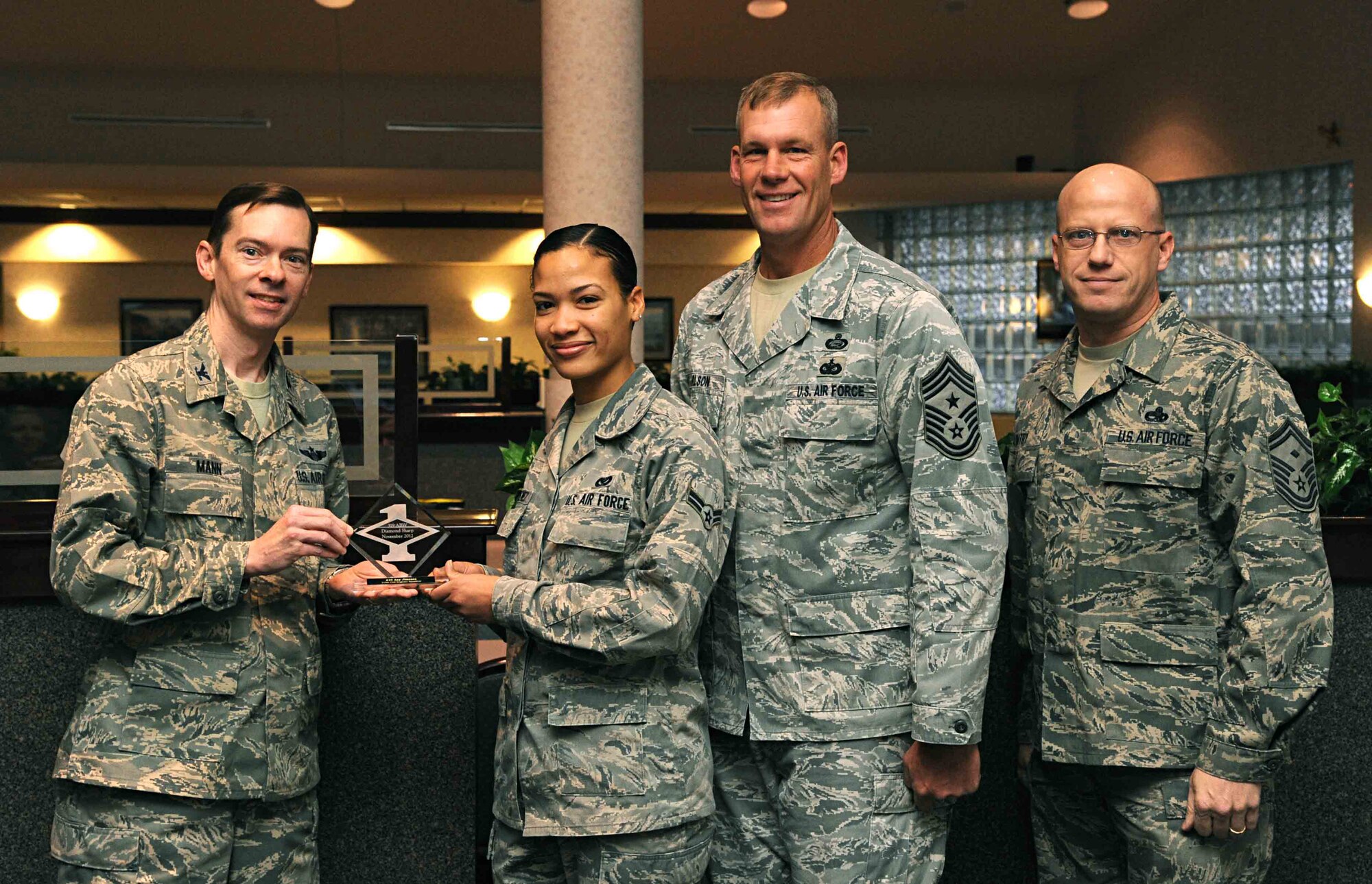 Col. Christopher Mann, 319th Air Base Wing vice commander, presents Airman 1st Class Any Jimenez, 319th Civil Engineer  Squadron, with a Diamond Sharp Award Nov. 15, 2012, at Airey Dining Facility on Grand Forks Air Force Base, N.D., accompanied by 319th ABW Command Chief Master Sgt. David Carlson and Senior Master Sgt. John Watry, 319th CES first sergeant.  The Diamond Sharp Award is given to Airmen who epitomize service before self and strive for excellence at work and off duty. (U.S. Air Force photo/Senior Airman Amber Bennett)