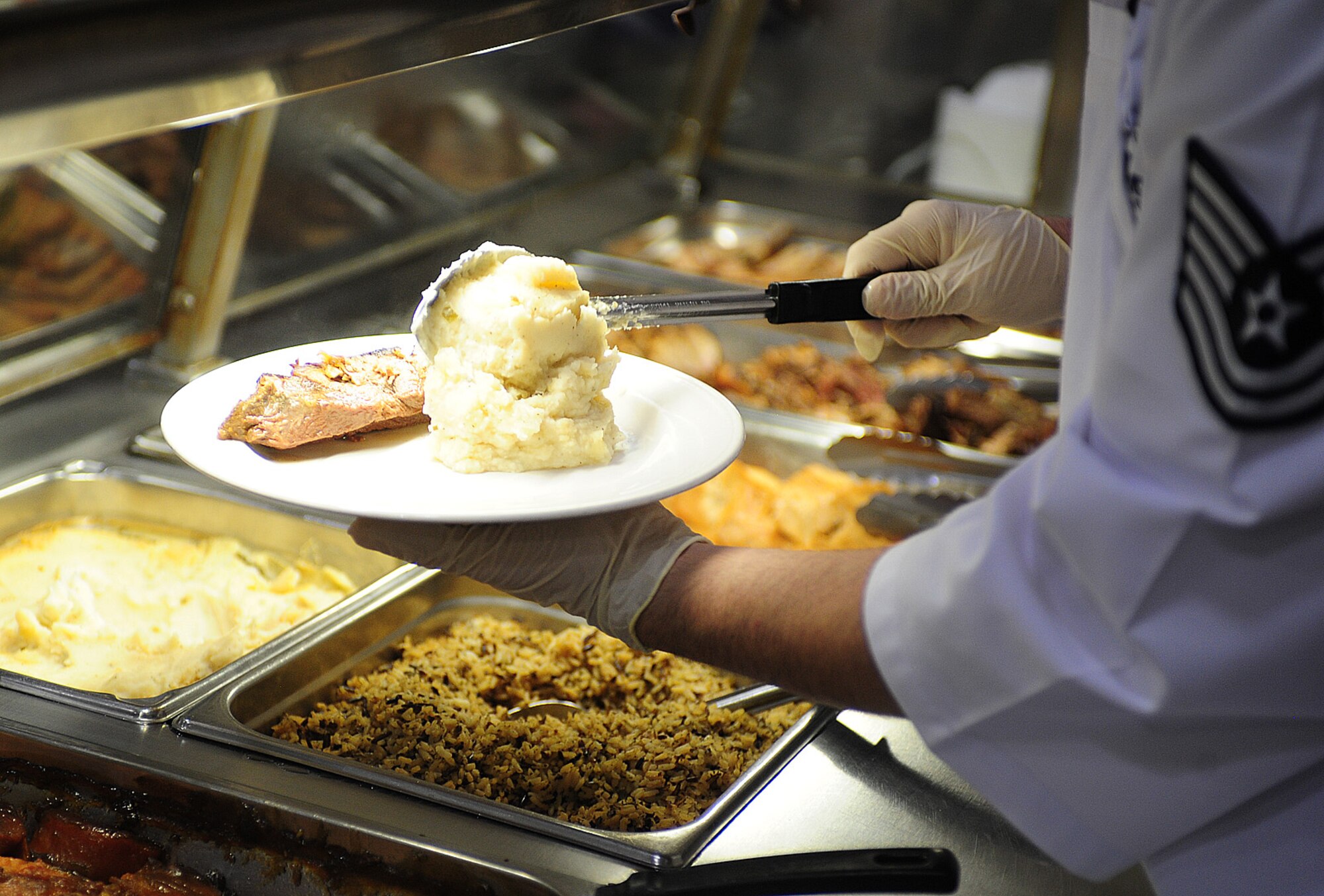 U.S. Air Force Tech. Sgt. Shawnn Anderson, 27th Special Operations Force Support Squadron, scoops mashed potatoes onto an Airman’s plate during the Thanksgiving meal at the Pecos Trail Dining Facility at Cannon Air Force Base, N.M., Nov. 22, 2012. The dining facility staff went to great lengths to provide a filling and heartwarming experience for the Airmen who were unable to be with their families during the holiday. (U.S. Air Force photo/Airman 1st Class Ericka Engblom)