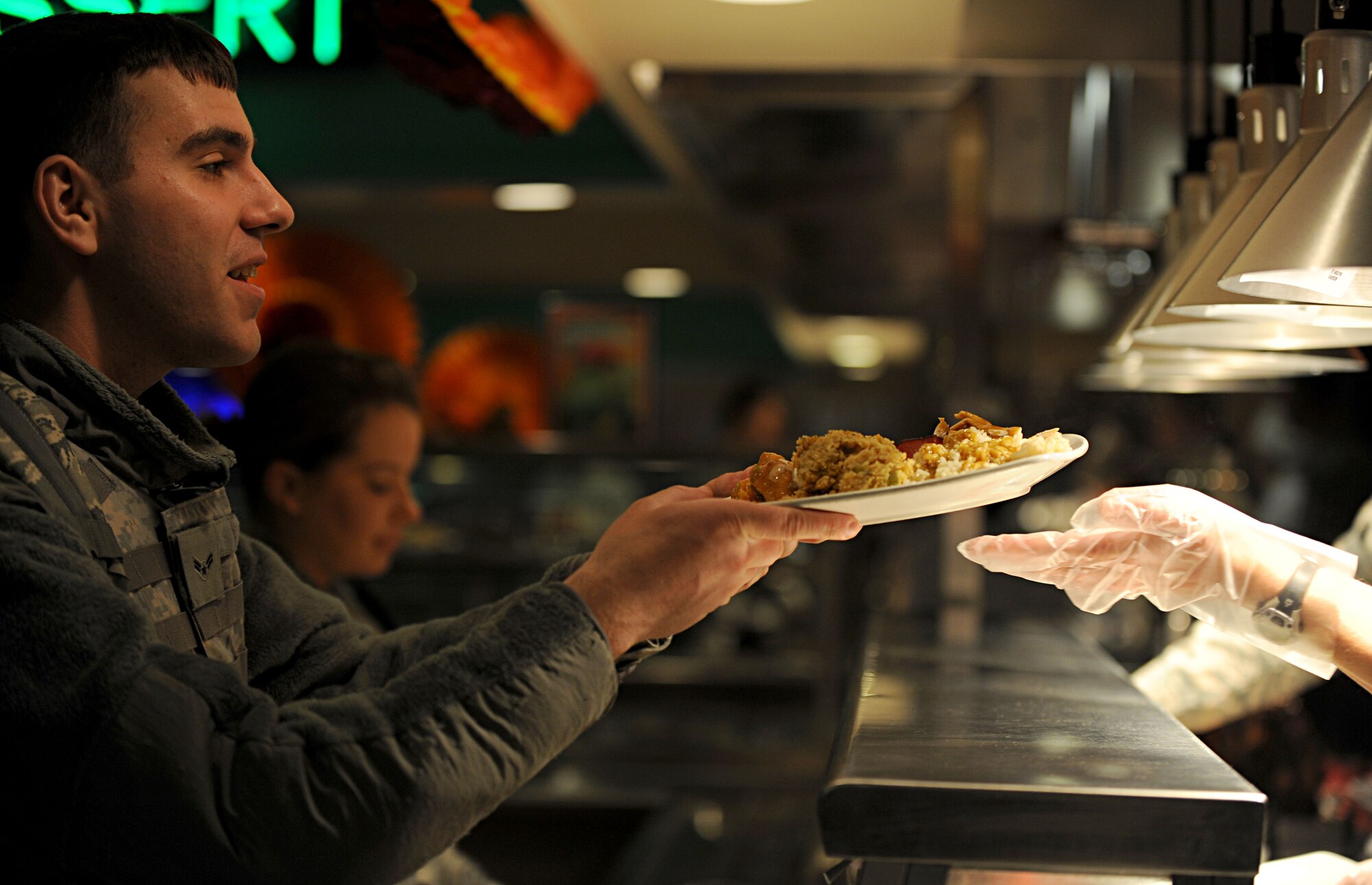 A Security Forces Airman is handed a plate of food by Col. Jayne Jansen, 633rd Air Base Wing vice commander, at the Langley Air Force Base, Va. dining facility, Nov. 22, 2012. Service members and their families were able to receive a traditional Thanksgiving meal from both Langley and Fort Eustis, Va. dining facilities (U.S. Air Force photo by Senior Airman Jarad A. Denton/Released) 
