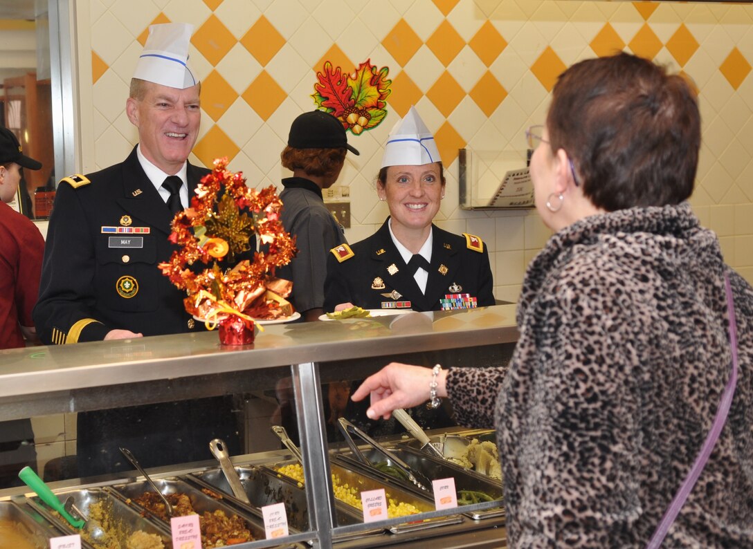 U.S. Army Maj. Gen. Bradley May, senior commander of Army Element Eustis and deputy commanding general of Initial Military Training, and Col. Jen Reinkober, 7th Sustainment Brigade commander, share holiday warmth with guests while working in the serving line during the Thanksgiving Day meal at the Resolute Cafe at Fort Eustis, Va., Nov. 22, 2012. More than 500 guests attended the meal, including Soldiers, family members and retirees. (U.S. Air Force photo by Senior Airman Jason J. Brown/Released)