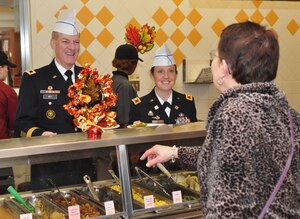 U.S. Army Maj. Gen. Bradley May, senior commander of Army Element Eustis and deputy commanding general of Initial Military Training, and Col. Jen Reinkober, 7th Sustainment Brigade commander, share holiday warmth with guests while working in the serving line during the Thanksgiving Day meal at the Resolute Cafe at Fort Eustis, Va., Nov. 22, 2012. More than 500 guests attended the meal, including Soldiers, family members and retirees. (U.S. Air Force photo by Senior Airman Jason J. Brown/Released)
