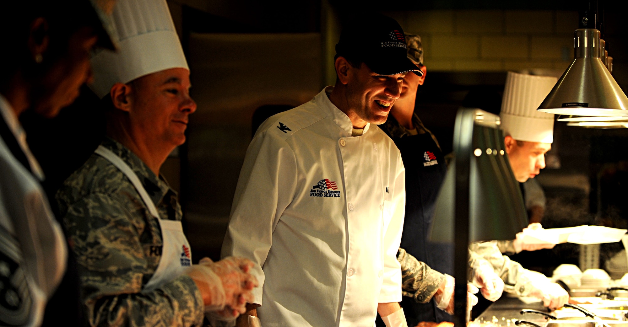 Col. Korvin Auch, 633rd Air Base Wing commander, laughs with patrons of the Langley Air Force Base, Va. dining facility, Nov. 22, 2012. Auch, along with leadership from both Langley and Fort Eustis, Va., devoted time during Thanksgiving to provide Service members and their families a traditional holiday meal. (U.S. Air Force photo by Senior Airman Jarad A. Denton/Released)