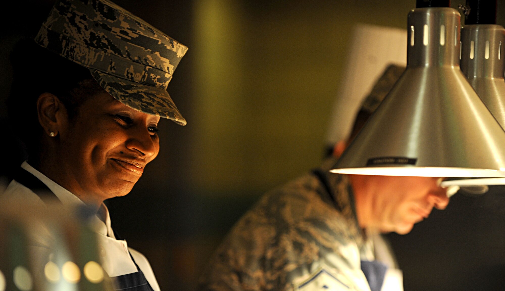 Chief Master Sgt. Trae King, 633rd Air Base Wing command chief, smiles while serving Airmen at the Langley Air Force Base dining facility, Nov. 22, 2012. King, and leaders from Langley and Fort Eustis, Va., provided Service members and their families with a traditional Thanksgiving dinner. (U.S. Air Force photo by Senior Airman Jarad A. Denton/Released)