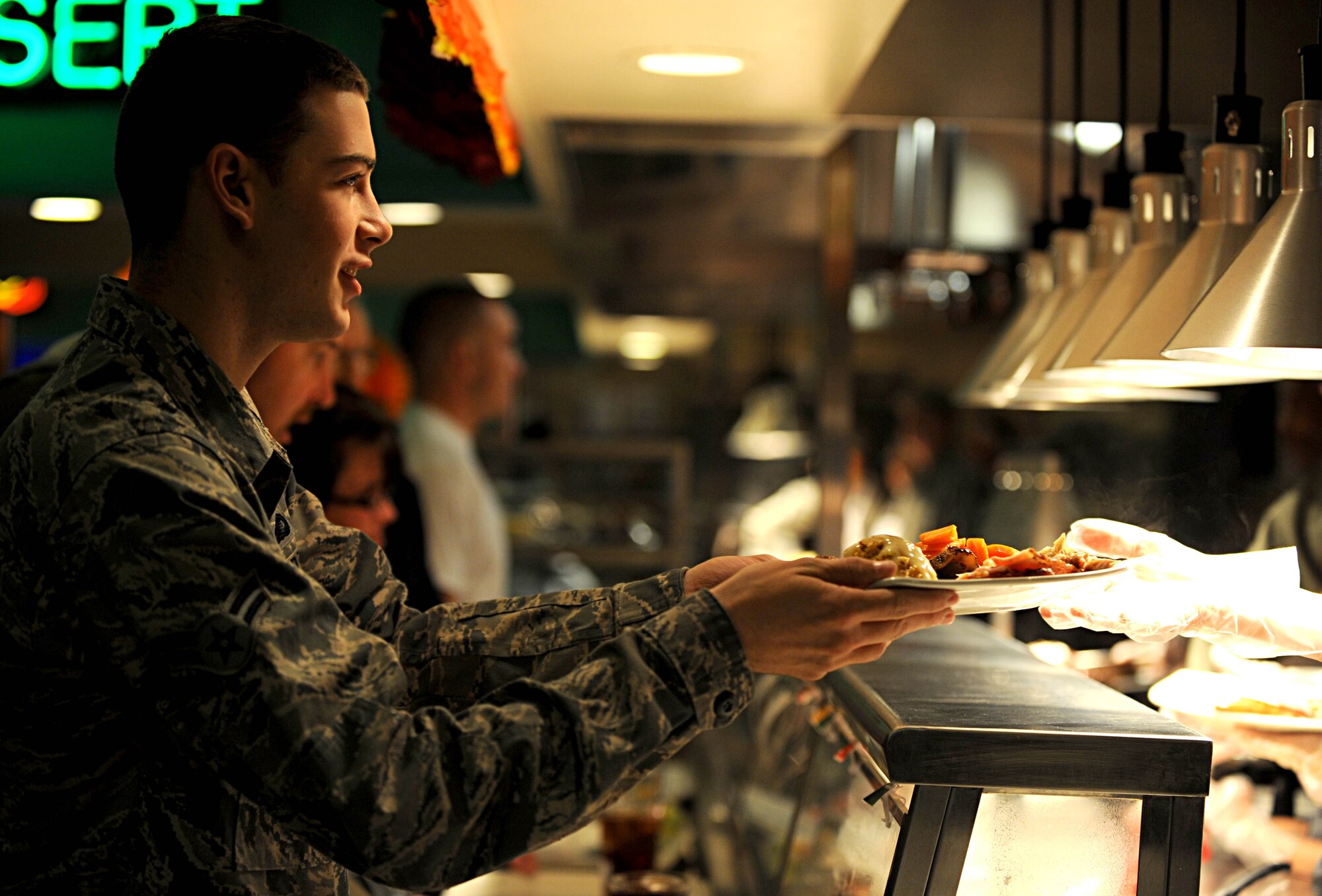 U.S. Army Col. Jayne Jansen, 633rd Air Base Wing vice commander, hands an Airman a plate of food at the Langley Air Force Base dining facility, Nov. 22, 2012. Base leadership from both Langley and Fort Eustis, Va. joined together to provide Service members and their families with a traditional Thanksgiving dinner. (U.S. Air Force photo by Senior Airman Jarad A. Denton/Released)
