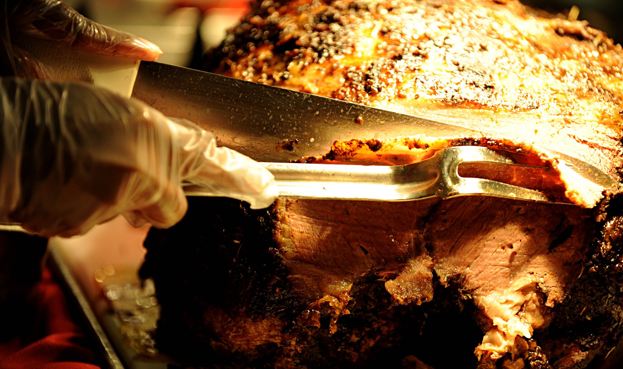 A Service member from Joint Base Langley-Eustis leadership carves a roast during the Thanksgiving day meal at the Langley Air Force Base, Va. dining facility, Nov. 22, 2012. The roast was slow-cooked for 16 hours, prior to being served to Airmen and their families. (U.S. Air Force photo by Senior Airman Jarad A. Denton/Released)