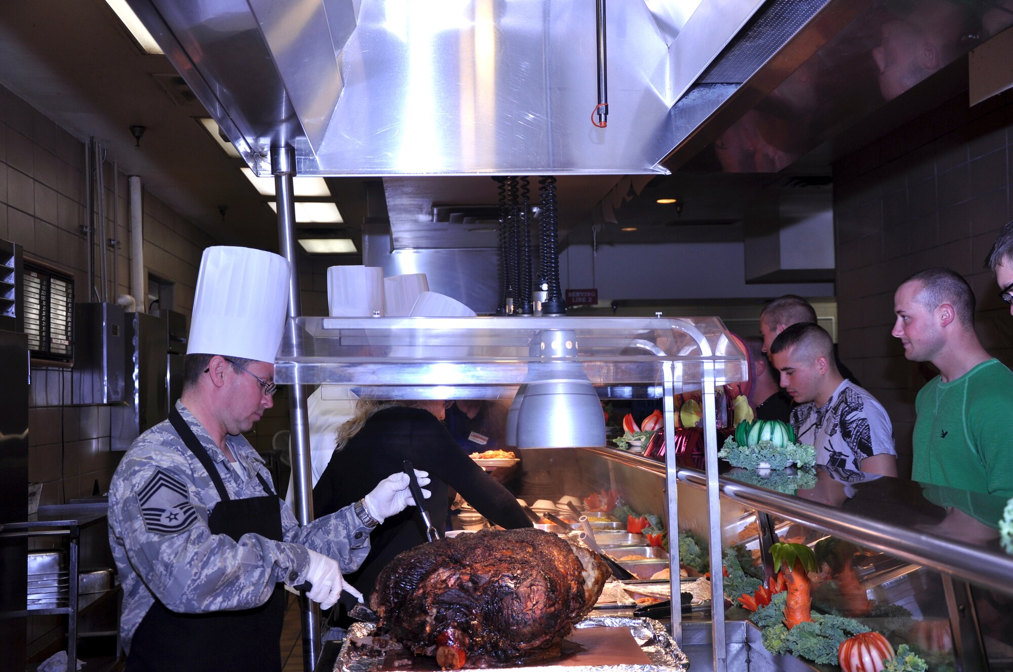 GOODFELLOW AIR FORCE BASE, Texas—Chief Master Sgt.  Raymond Irizarry, 17th Training Group superintendant, carves a roast during a Thanksgiving Day lunch at the Western Winds dining facility Nov. 22.  Base leadership served the holiday meal to junior service members, retirees and dependents. (U.S. Air Force photo/Airman 1st Class Jessica Keith)