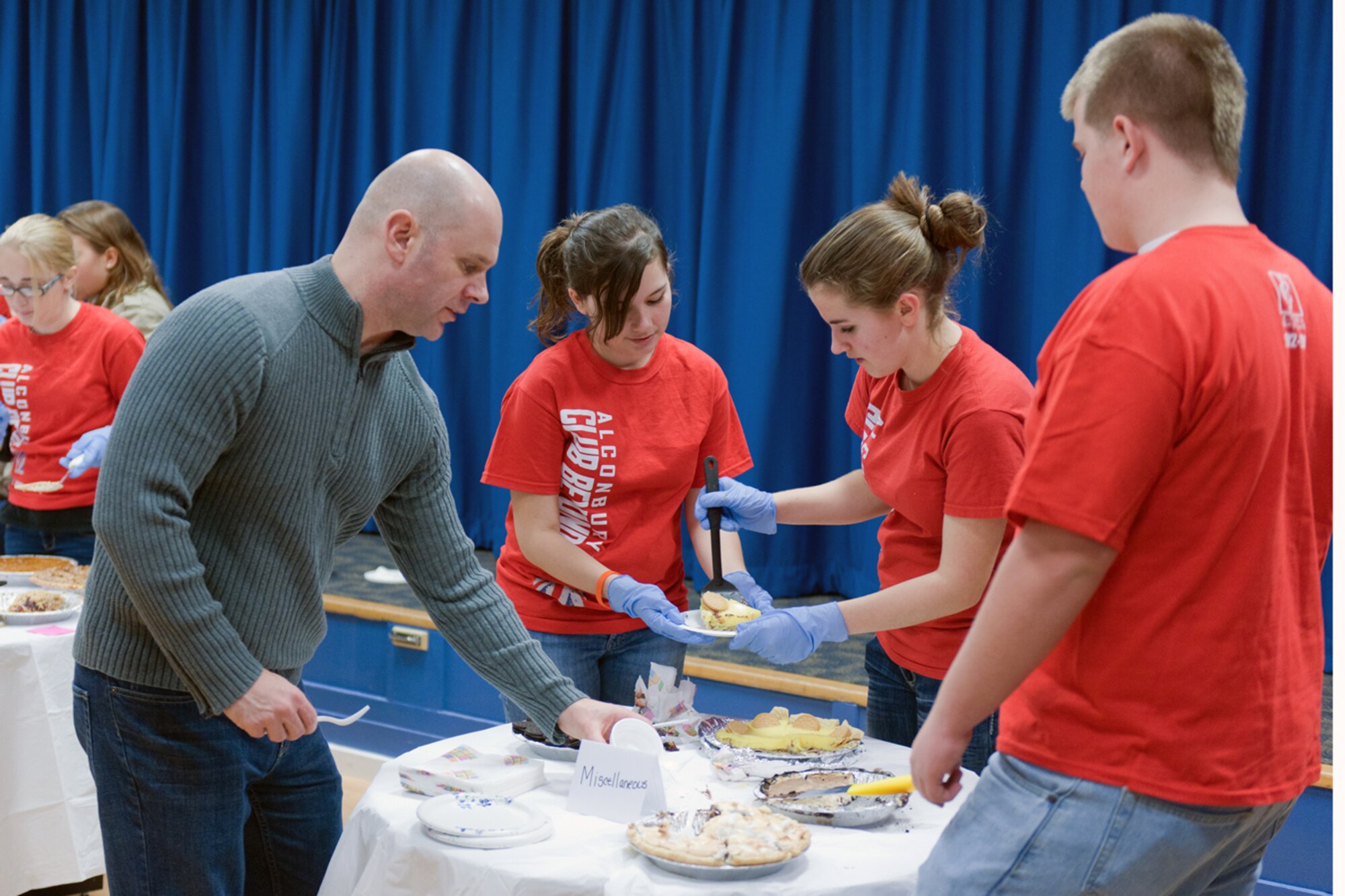 RAF ALCONBURY, United Kingdom – Members of the Alconbury Club Beyond serve pie to members of the 501st Combat Support Wing and local communities as part of the Thanksgiving Pie Social at the Community Activity Center Nov. 21. The RAF Alconbury Chapel hosted the social and the women of the chapel baked more than 80 pies for the event. (U.S. Air Force photo by Staff Sgt. Brian Stives)