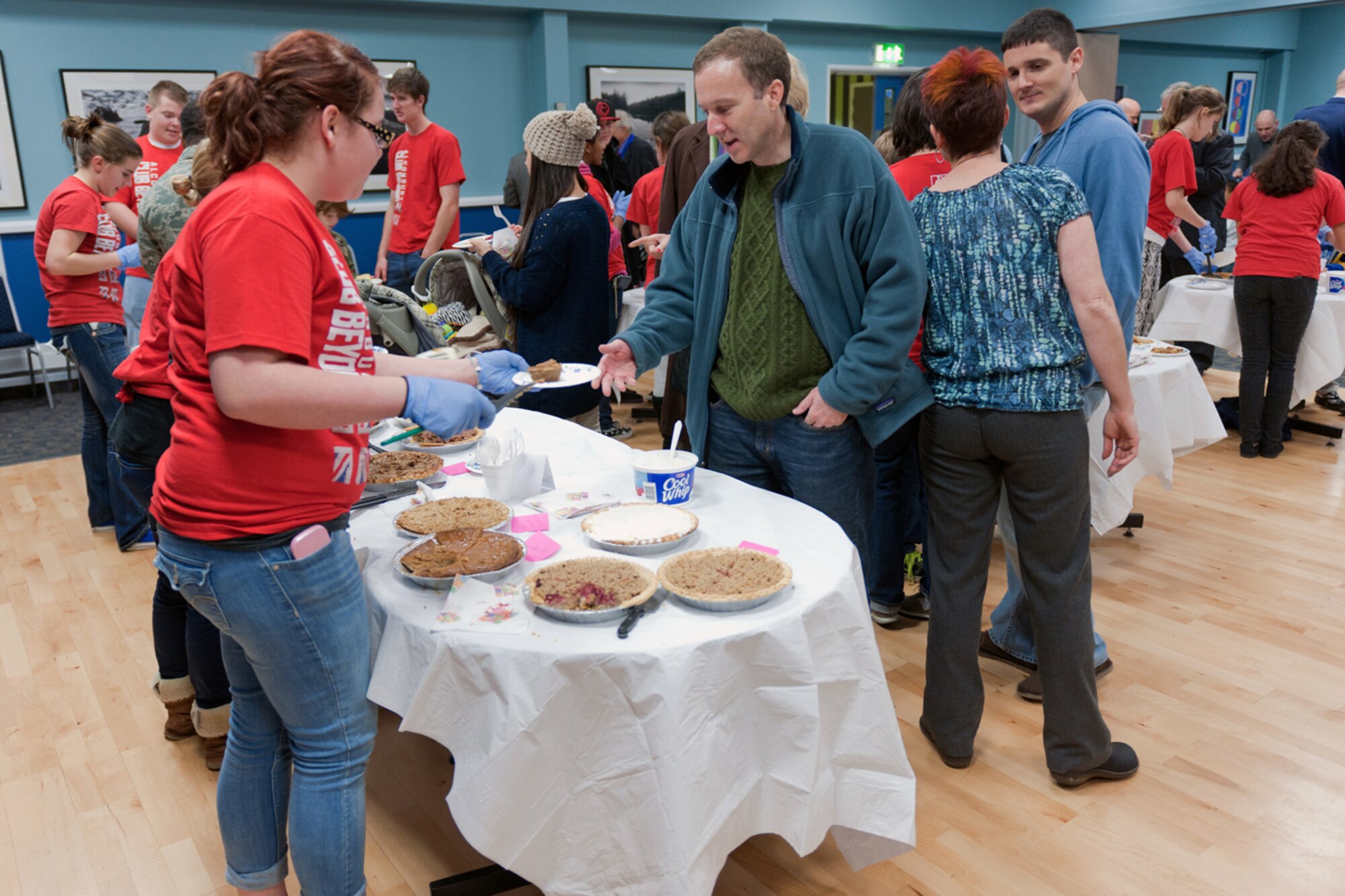 RAF ALCONBURY, United Kingdom – Members of the Alconbury Club Beyond serve pie to members of the 501st Combat Support Wing and local communities as part of the Thanksgiving Pie Social at the Community Activity Center Nov. 21. The RAF Alconbury Chapel hosted the social and the women of the chapel baked more than 80 pies for the event. (U.S. Air Force photo by Staff Sgt. Brian Stives)