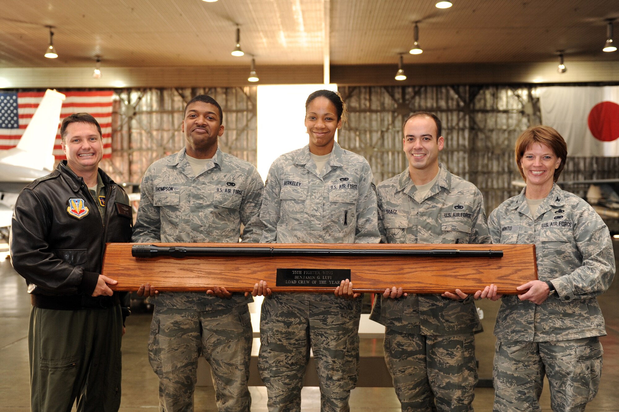 U.S. Air Force Col. Matthew Dana, 35th Fighter Wing vice commander, far left, and Col. Cheryl Minto, 35th Maintenance Group commander, far right, present Senior Airmen Armanni Thompson and Shateria Berkley and Staff Sgt. Esteban Maiz, 13th Aircraft Maintenance Unit weapons load crew members, with the Load Crew of the Year trophy at Misawa Air Base, Japan, Nov. 21, 2012. The 13 AMU load crew won this year’s competition with a load time of 19:29 and a total of 1,345 points and will represent the base the Pacific Air Forces Load Crew of the Year award. (U.S. Air Force photo by Airman 1st Class Kia Atkins)