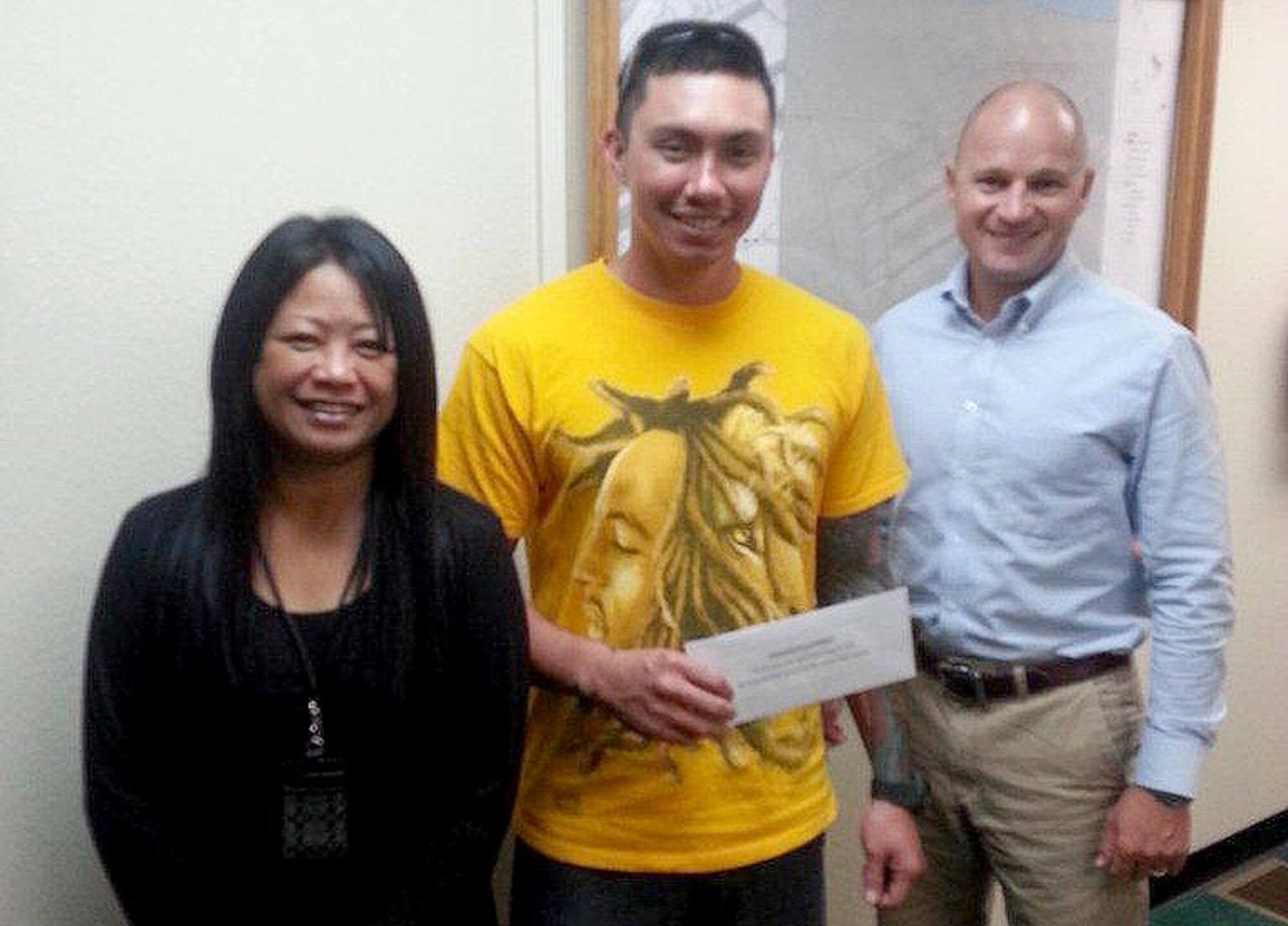 ANDERSEN AIR FORCE BASE, Guam - Machinist Mate 2nd Class Kawika Hines, from USS Key West (SSN 722), stands with Yvette Bordallo, 36th Civil Engineering Squadron environmental protection specialist and recycle manager, and Joe Vinch, 36th CES environmental flight chief, after winning a gift certificate during the America Recycles Day event here Nov. 15. America Recycles Day is nationally recognized day dedicated to promoting and celebrating recycling in the United States. (Courtesy photo)