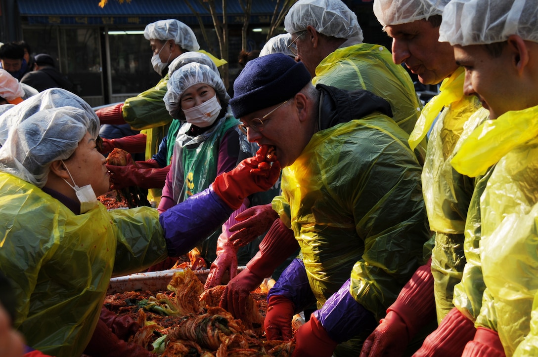 Basil Meyer, from Construction Division, Northern Resident Office, tastes a piece of kimchi he helped make with volunteers. Members of FED volunteered to help make kimchi for local charities on Nov. 22 as part of the Good Neighbor Program.